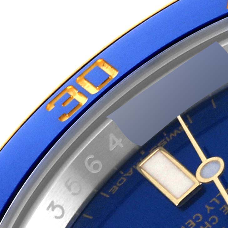 The image shows a close-up angle of the Rolex Submariner 116613 Men
s Steel and Gold (two tone) Blue Dial 116613 Men
s Steel and Gold (two tone) Blue Dial watch, focusing on the bezel and part of the dial.