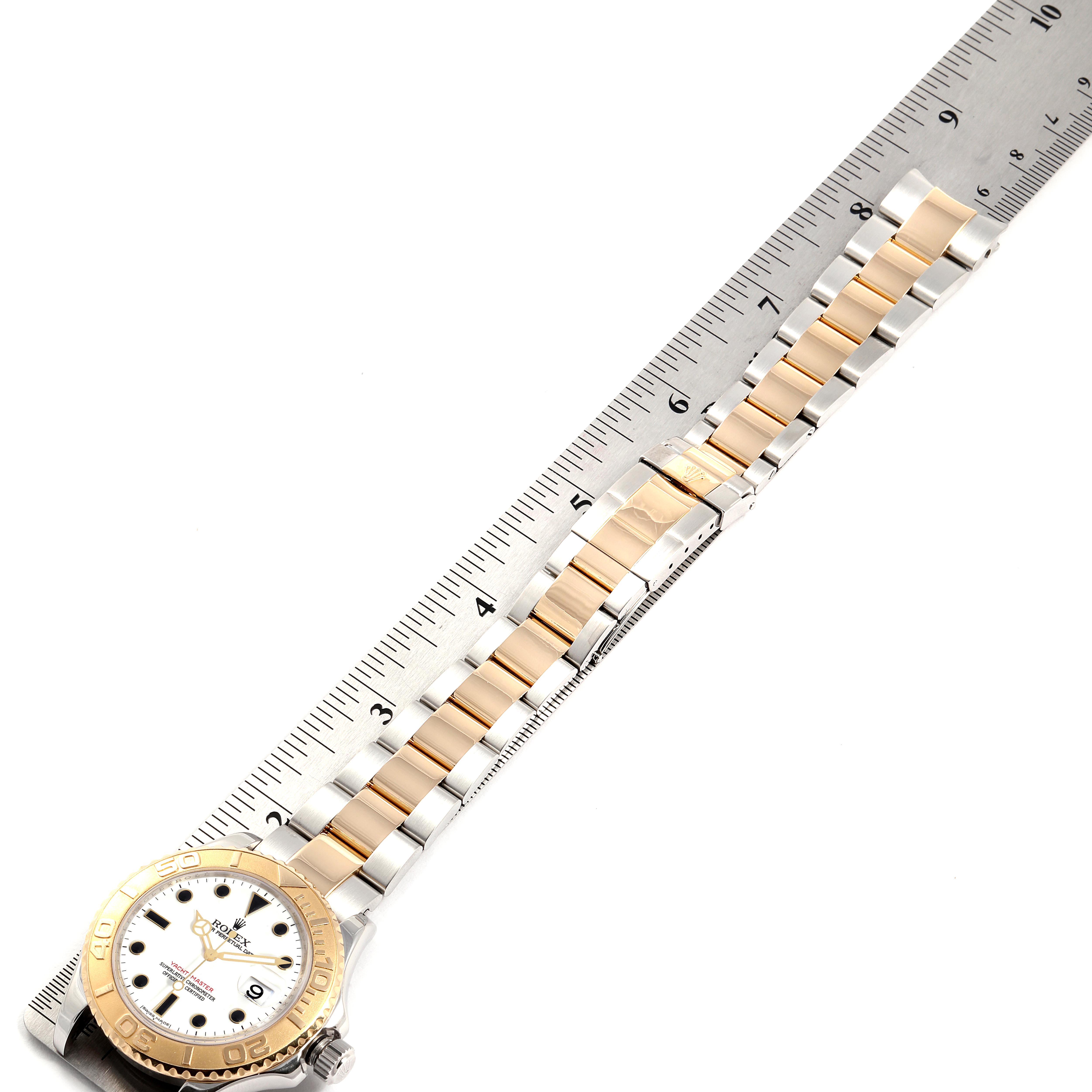 The Rolex Yacht-Master 16623 Men's Steel and Gold (two tone) White Dial 16623 Men's Steel and Gold (two tone) White Dial watch is shown flat with its bracelet extended and aligned with a ruler.