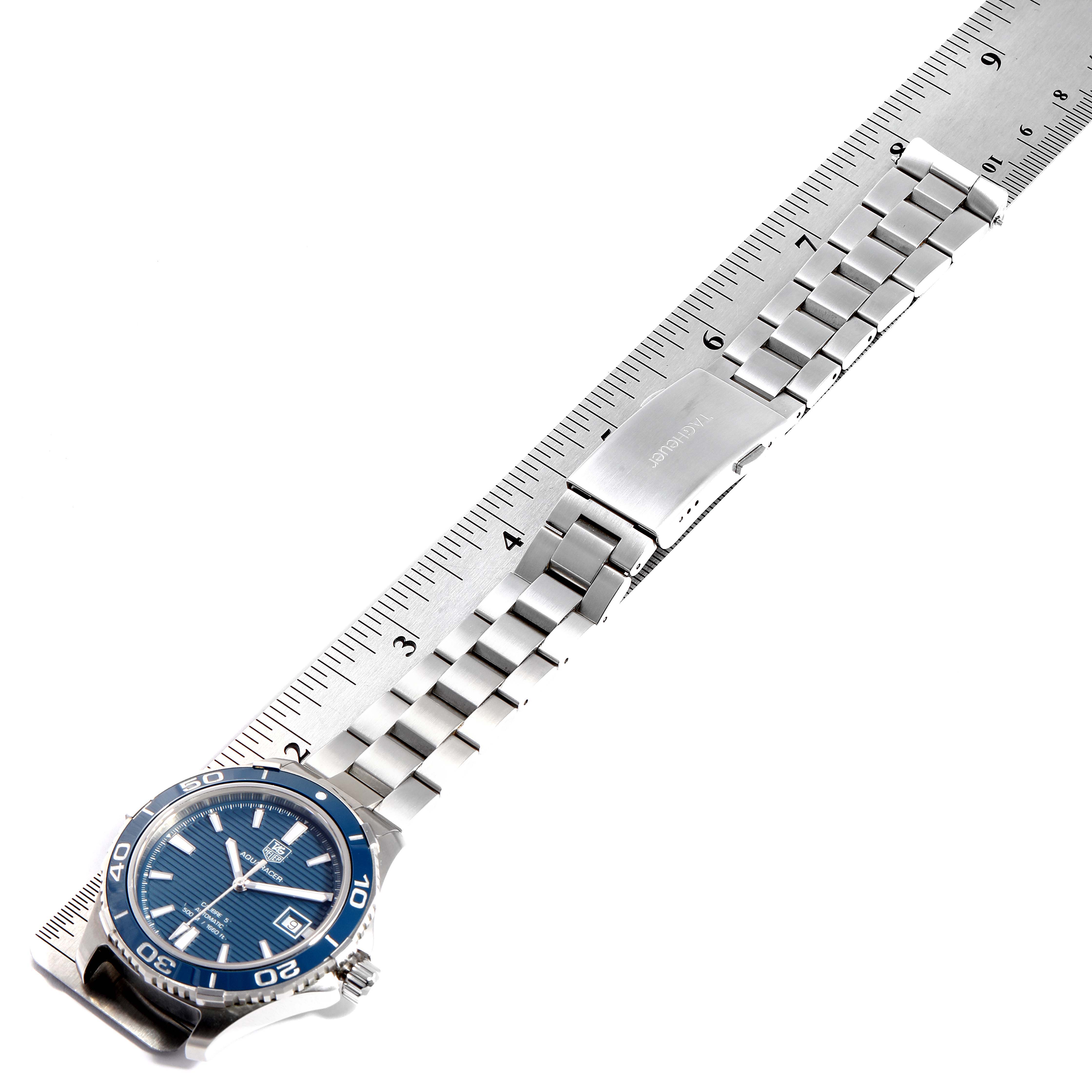 The image shows a Tag Heuer Aquaracer WAK2111.BA0830 Men's Stainless Steel Blue Dial WAK2111.BA0830 Men's Stainless Steel Blue Dial watch laid flat next to a ruler, highlighting its stainless steel bracelet and clasp.