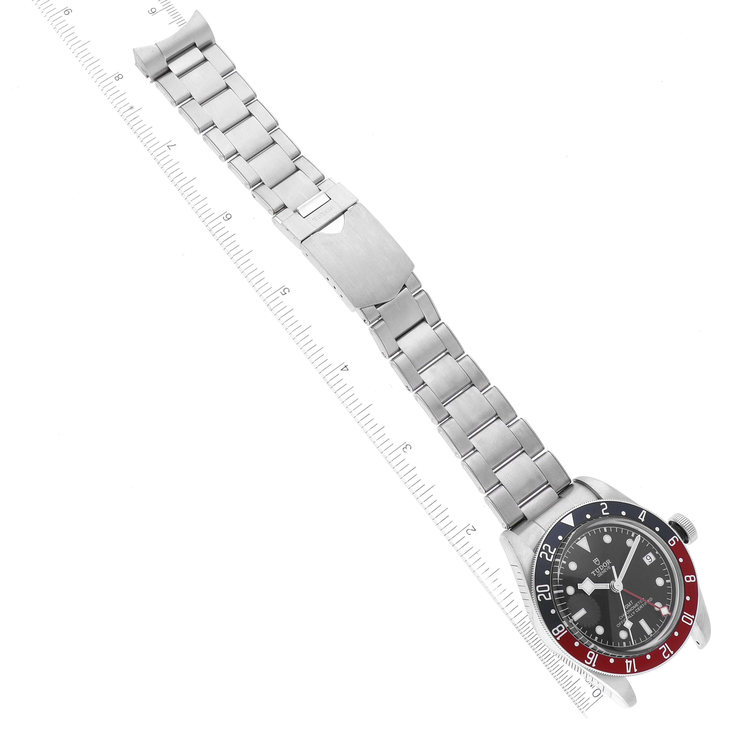 The image shows a Tudor Heritage Black Bay 79830RB Men
s Stainless Steel Black Dial 79830RB Men
s Stainless Steel Black Dial watch laid flat with its stainless steel bracelet extended and a ruler for measurement.