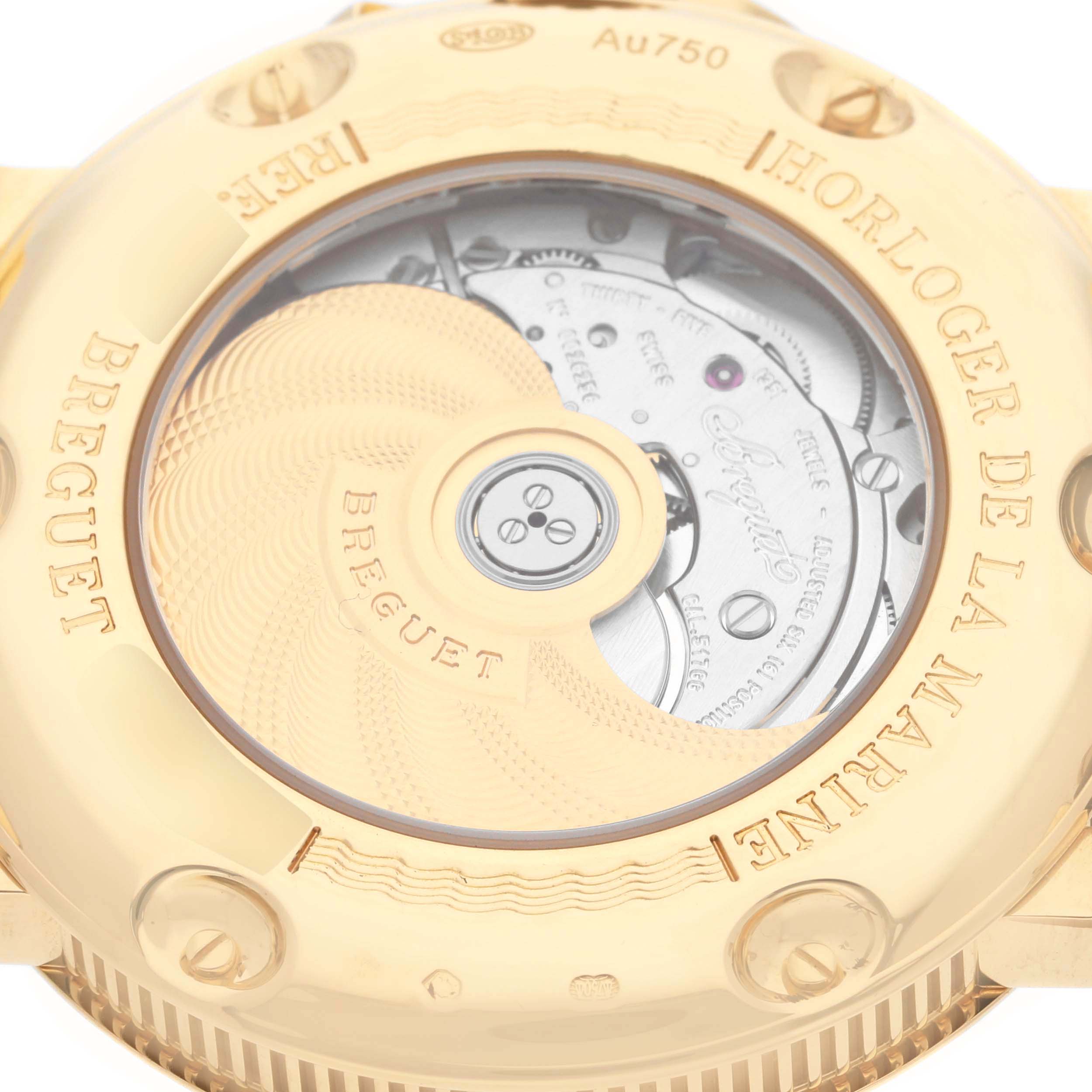 The image shows the back of the Breguet Marine 5817BA/12/9V8 Men
s Yellow Gold Silver Dial 5817BA/12/9V8 Men
s Yellow Gold Silver Dial watch, highlighting the movement and gold case with "Horloger de la Marine."