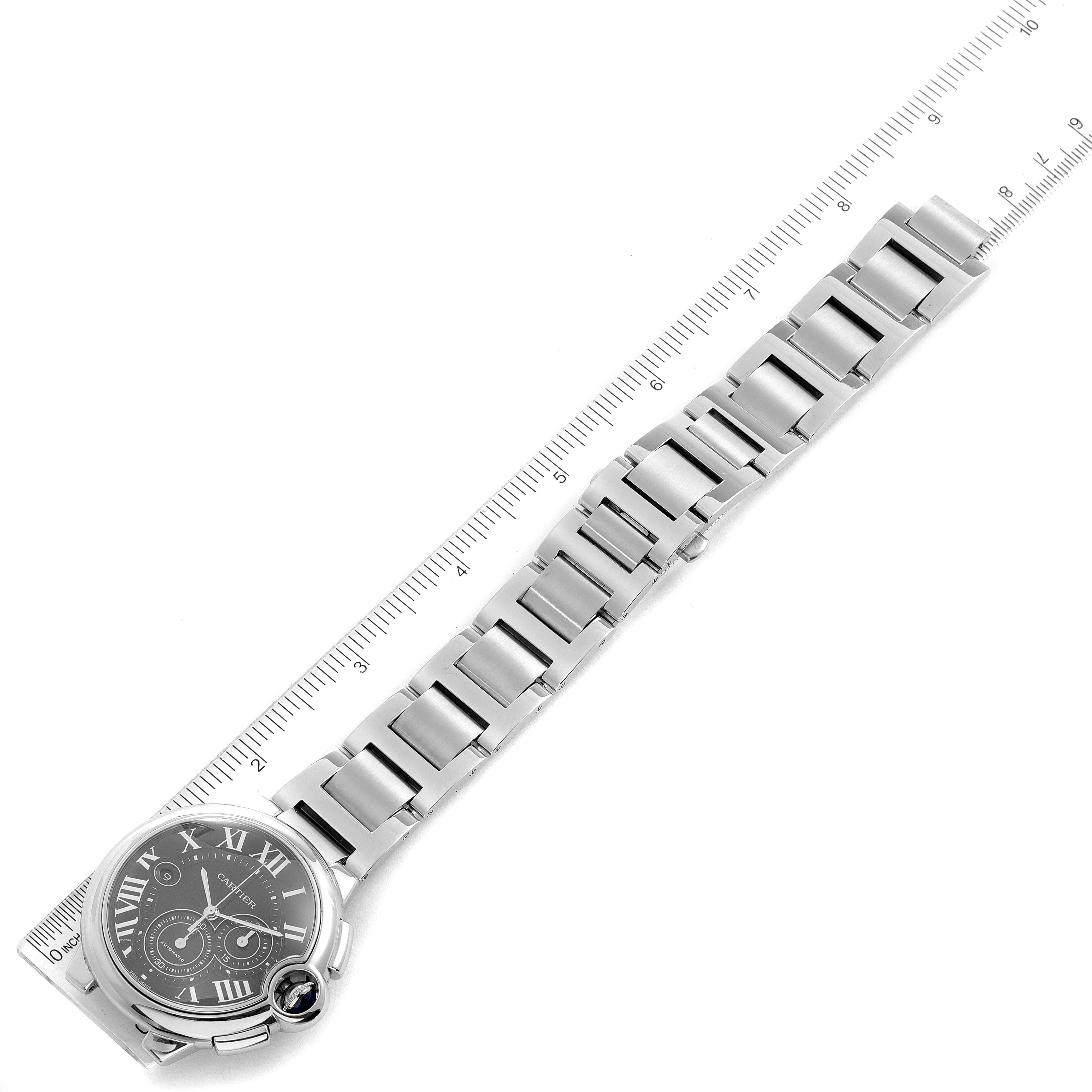 This image shows a top-down view of a Cartier Ballon Bleu W6920077 Men's Stainless Steel Black Dial W6920077 Men's Stainless Steel Black Dial watch, including its face and metal bracelet beside a ruler.