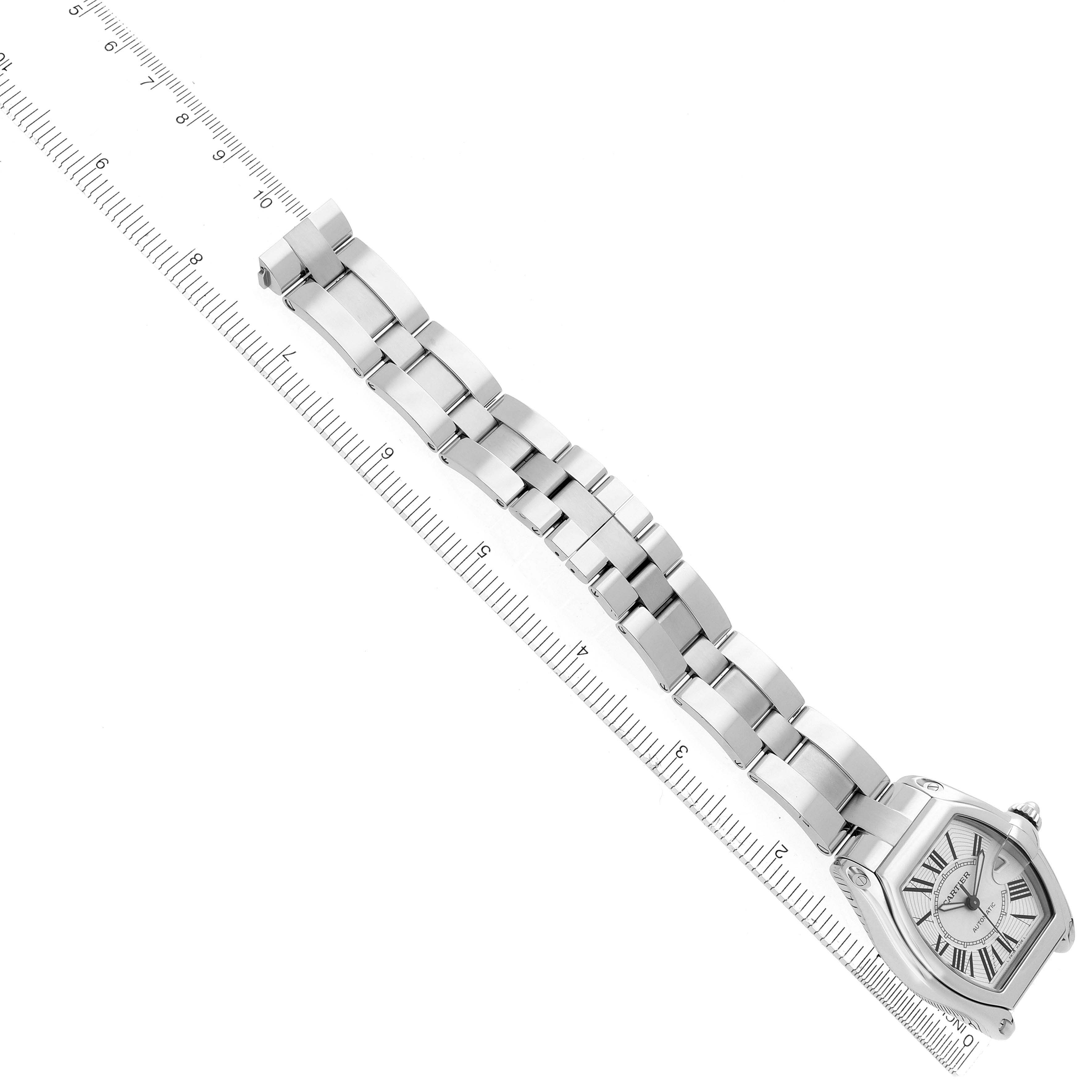 The Cartier Roadster W62025V3 Men's Stainless Steel Silver Dial W62025V3 Men's Stainless Steel Silver Dial watch is shown from a top-down angle, displaying the face and full metal bracelet alongside a ruler.