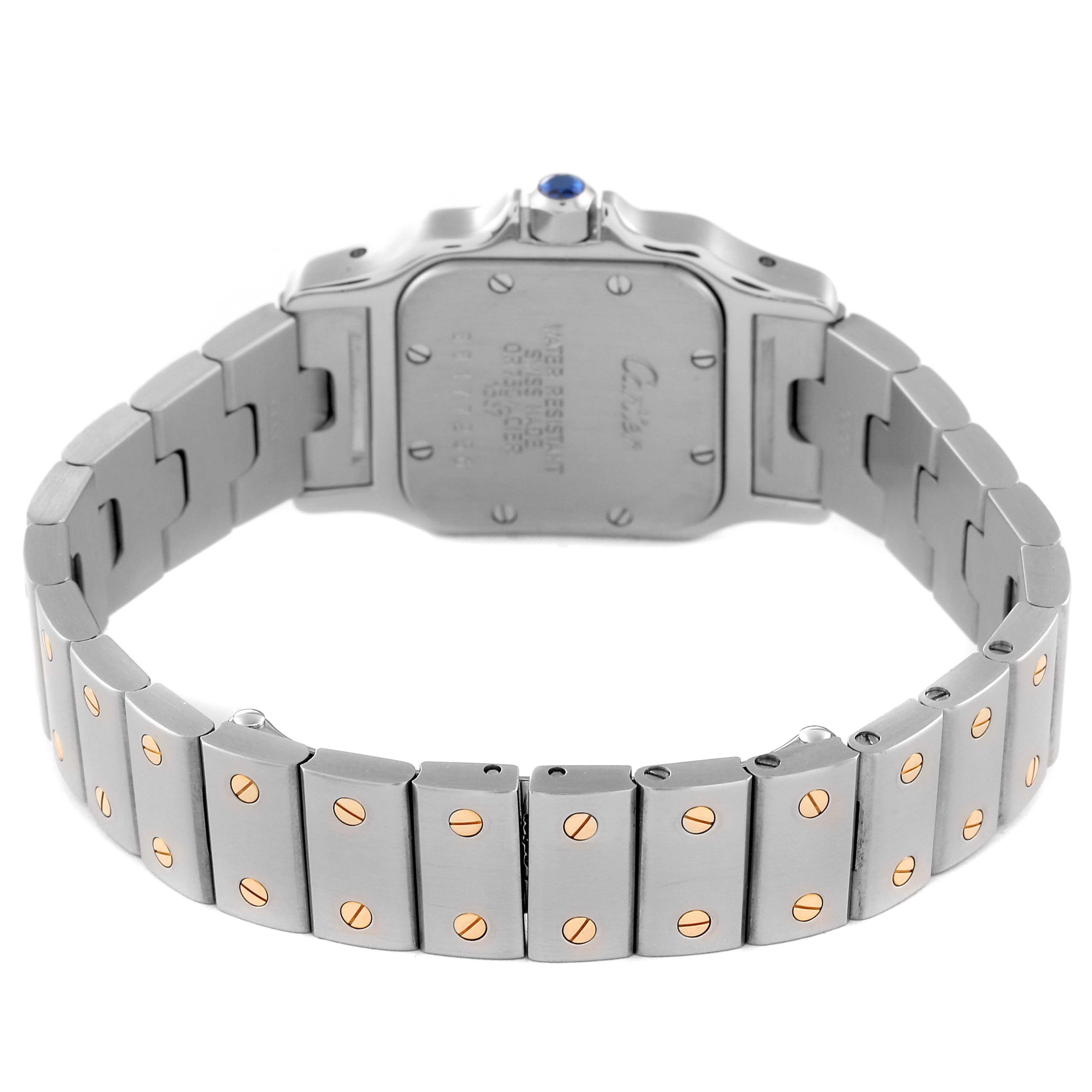 The image shows the backside and bracelet of the Cartier Santos W20012C4 Women's Steel and Gold (two tone) Silver Dial W20012C4 Women's Steel and Gold (two tone) Silver Dial watch, featuring a metal bracelet with gold screws and a sapphire crown.