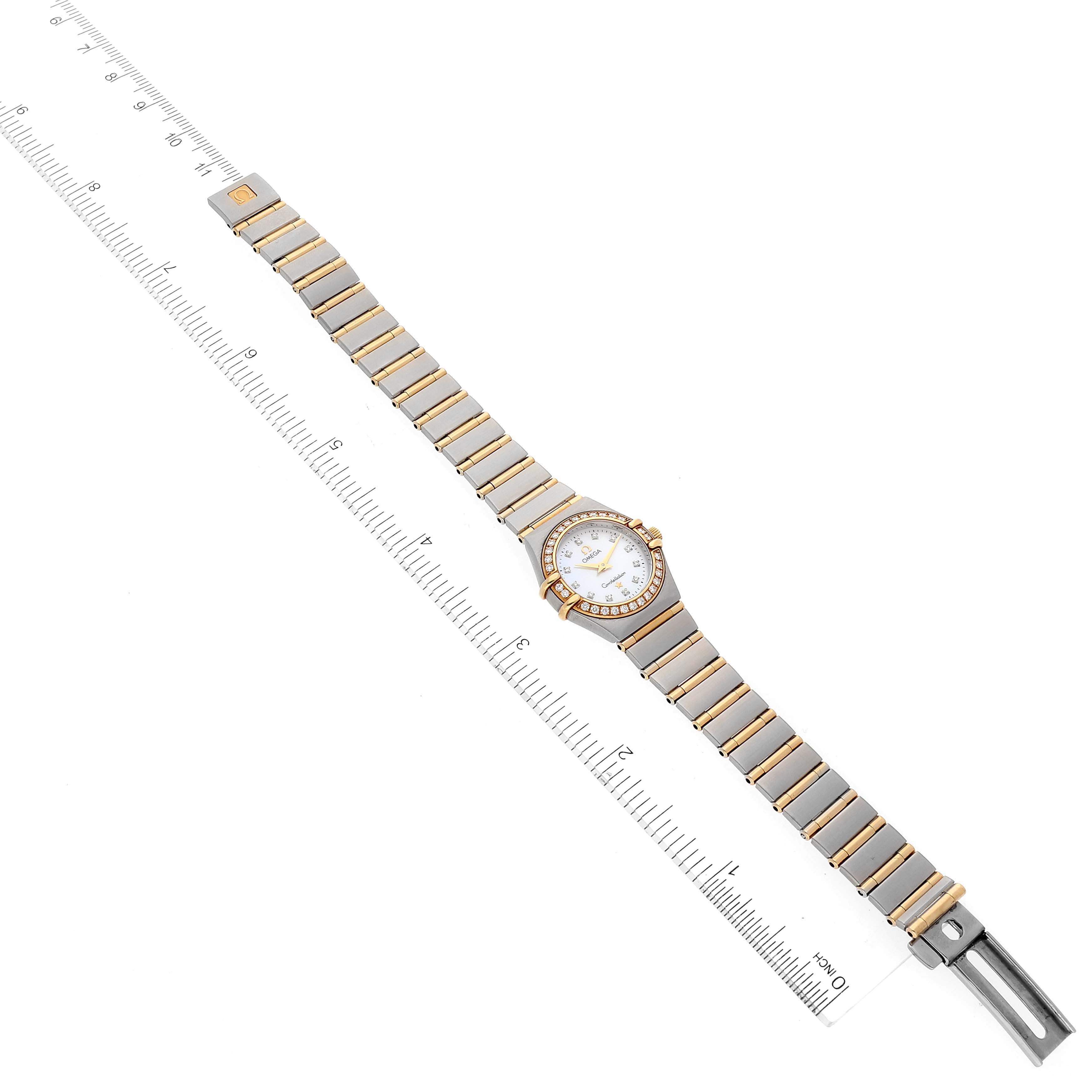 The Omega 1267.75.00 Women's Steel and Gold (two tone) Mother of Pearl Dial 1267.75.00 Women's Steel and Gold (two tone) Mother of Pearl Dial Constellation 95 Mother of Pearl Diamond Ladies Watch 1267.75.00 is shown flat with the dial facing up, alongside a ruler.