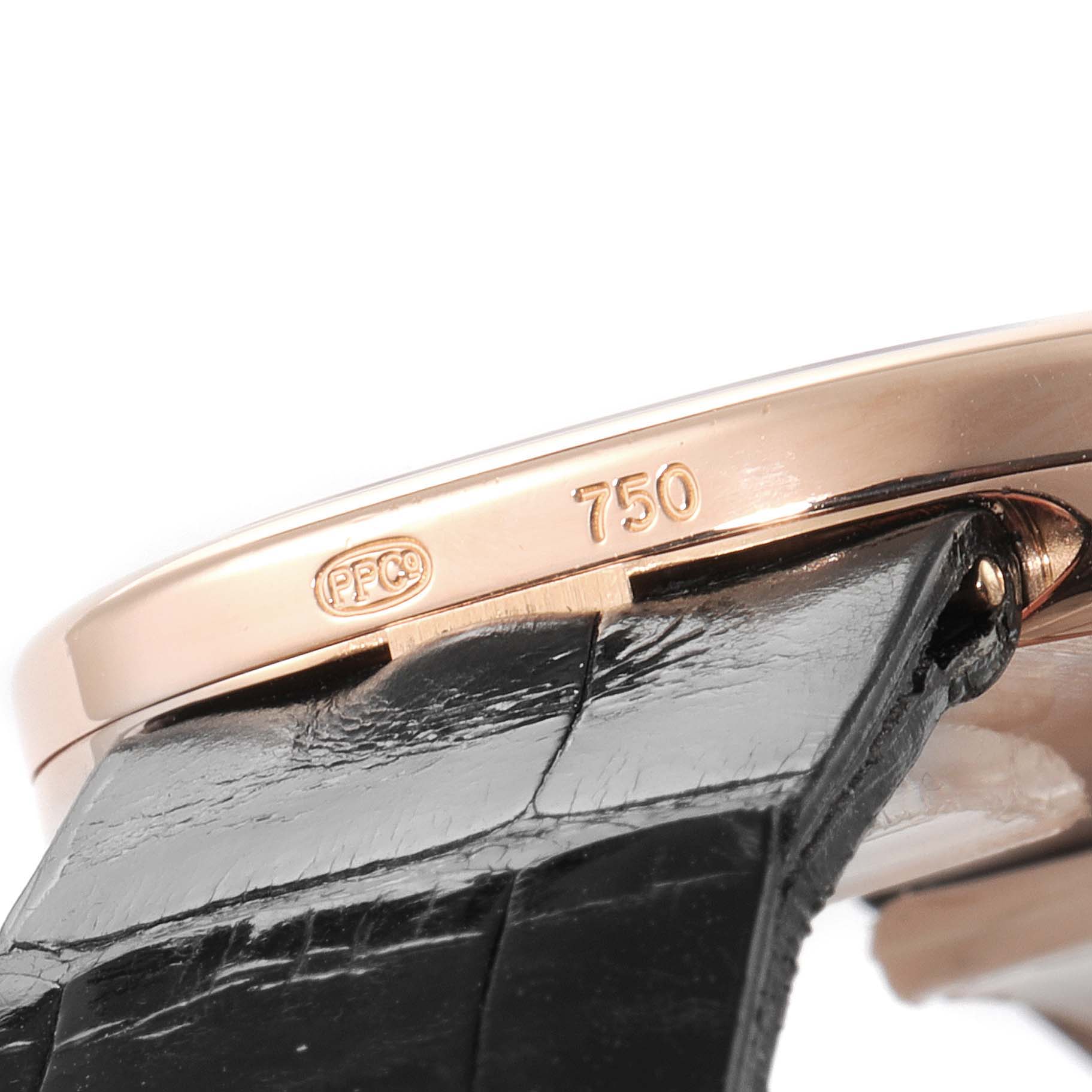 This close-up of a Patek Philippe Golden Ellipse 3738 Men's Rose Gold Brown Dial 3738 Men's Rose Gold Brown Dial watch shows the edge of the case and part of the black leather strap.