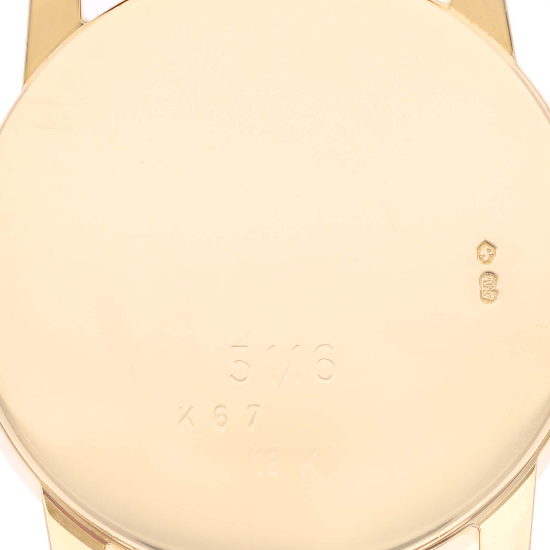 This image shows the back case of a Rolex Cellini 5116 Men's Yellow Gold Champagne Dial 5116 Men's Yellow Gold Champagne Dial watch from a straight-on angle, displaying engraved numbers and hallmarks.
