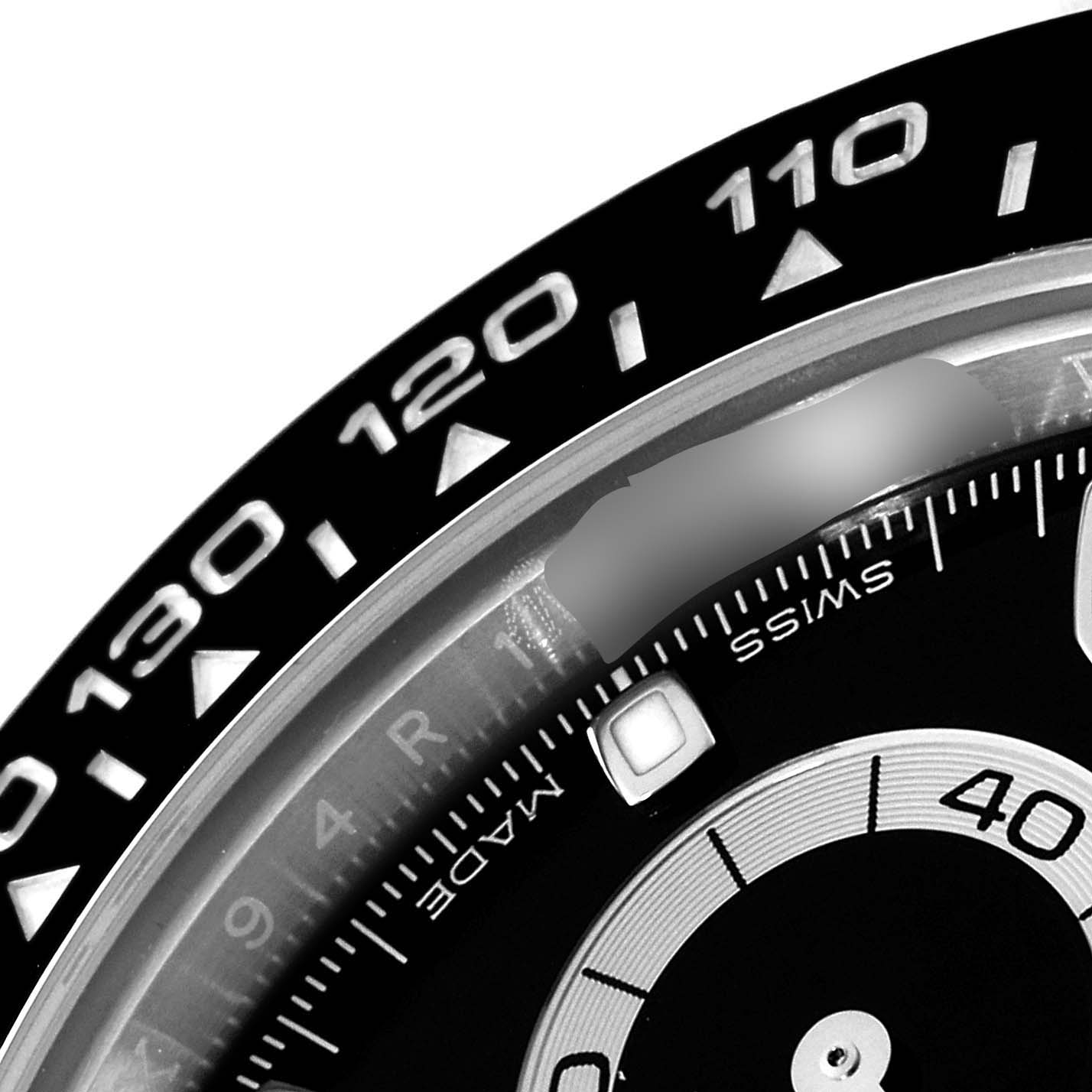 The image shows a close-up of the bezel and a portion of the dial of a Rolex Daytona 116500 Men's Stainless Steel Black Dial 116500 Men's Stainless Steel Black Dial watch.