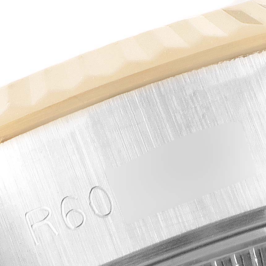 The image shows a close-up view of the Rolex Datejust 69173 Women
s Steel and Gold (two tone) Champagne Dial 69173 Women
s Steel and Gold (two tone) Champagne Dial watch bezel and part of the engraved side with the "R60" marking.