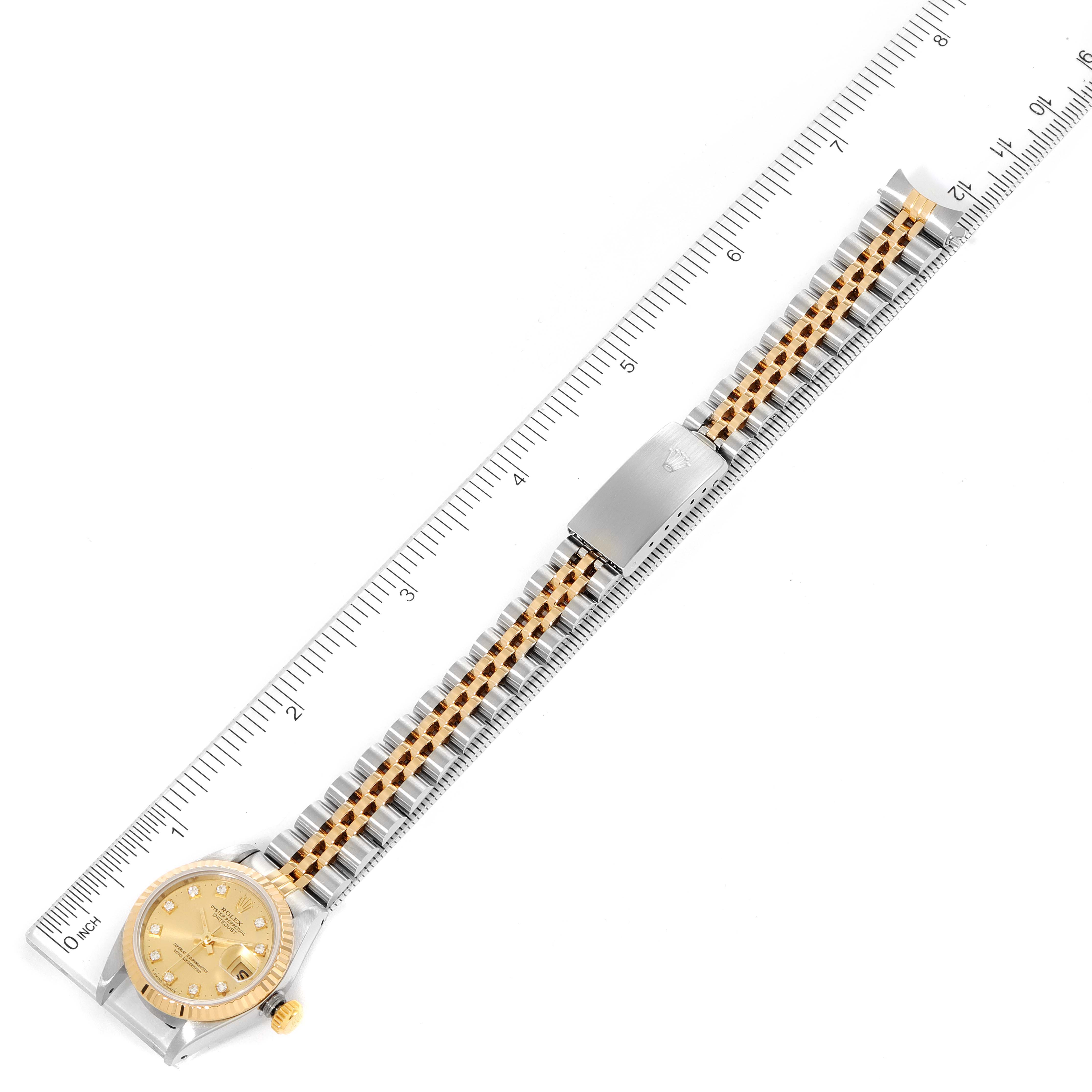This image shows a top-down view of a Rolex Datejust 69173 Women
s Steel and Gold (two tone) Champagne Dial 69173 Women
s Steel and Gold (two tone) Champagne Dial watch, specifically displaying its full band, dial, and clasp alongside a ruler.