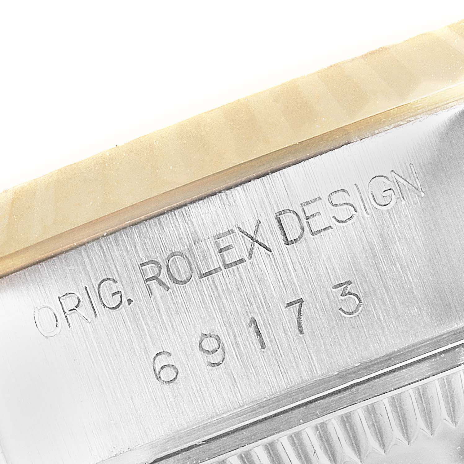 This image shows a close-up of the side of a Rolex Datejust 69173 Women
s Steel and Gold (two tone) Champagne Dial 69173 Women
s Steel and Gold (two tone) Champagne Dial watch, highlighting its model number and "ORIG. ROLEX DESIGN" engraving.