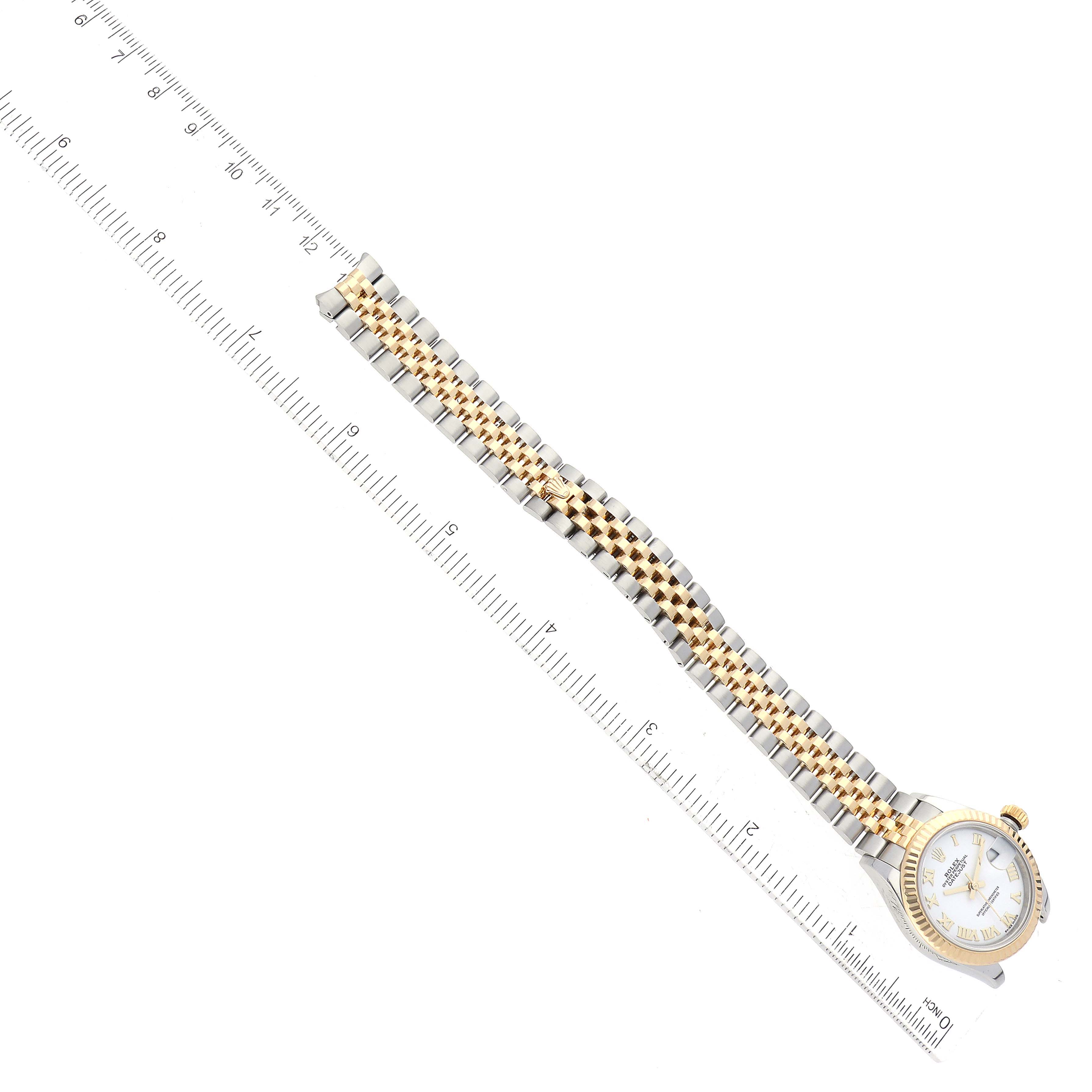The Rolex Datejust 279173 Women's Steel and Gold (two tone) White Dial 279173 Women's Steel and Gold (two tone) White Dial watch is shown from an overhead angle, highlighting its band and partial face next to a ruler.
