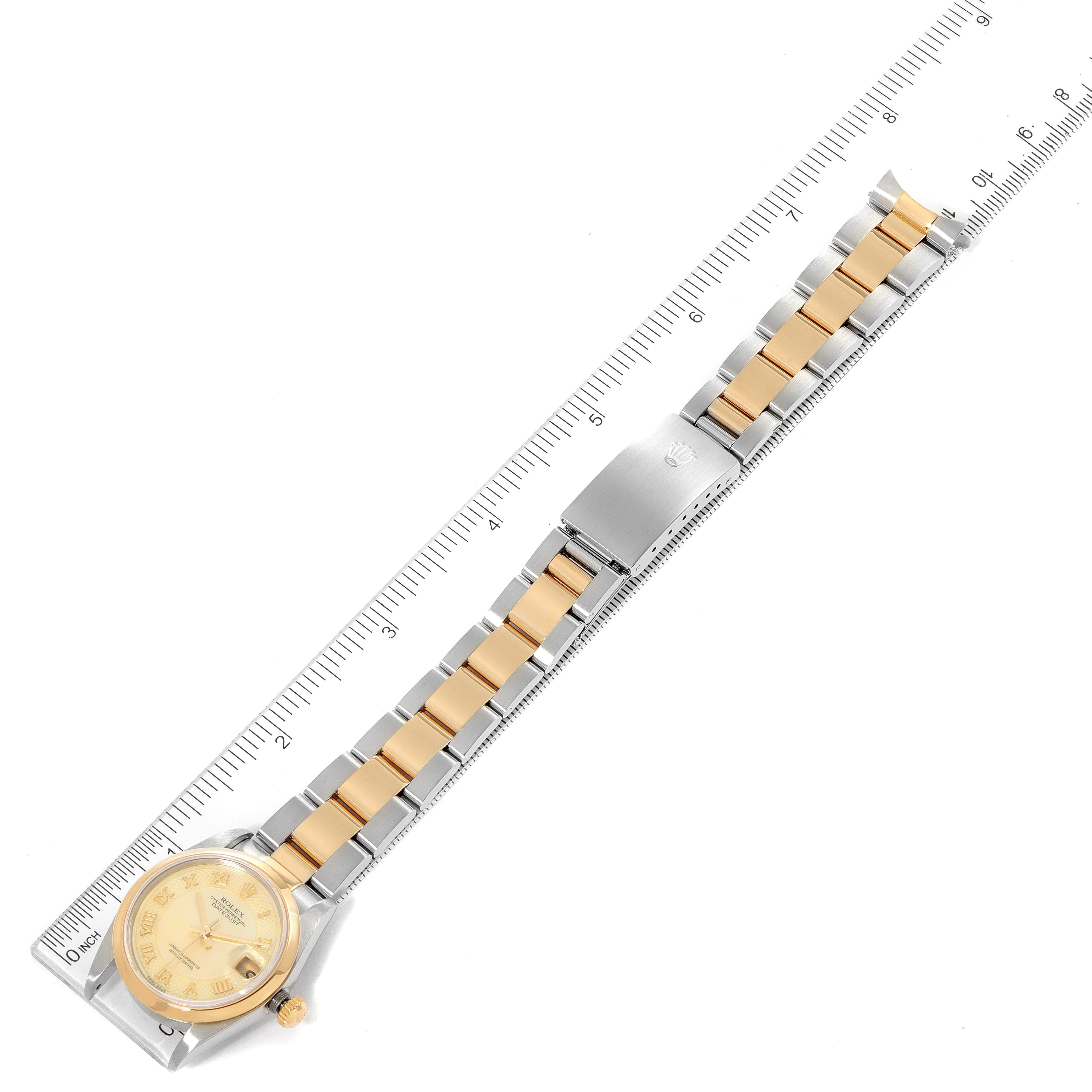 The image shows an overhead view of a Rolex Mid-Size 78243 Women's Steel and Gold (two tone) Mother of Pearl Dial 78243 Women's Steel and Gold (two tone) Mother of Pearl Dial watch with its band measured against a ruler.