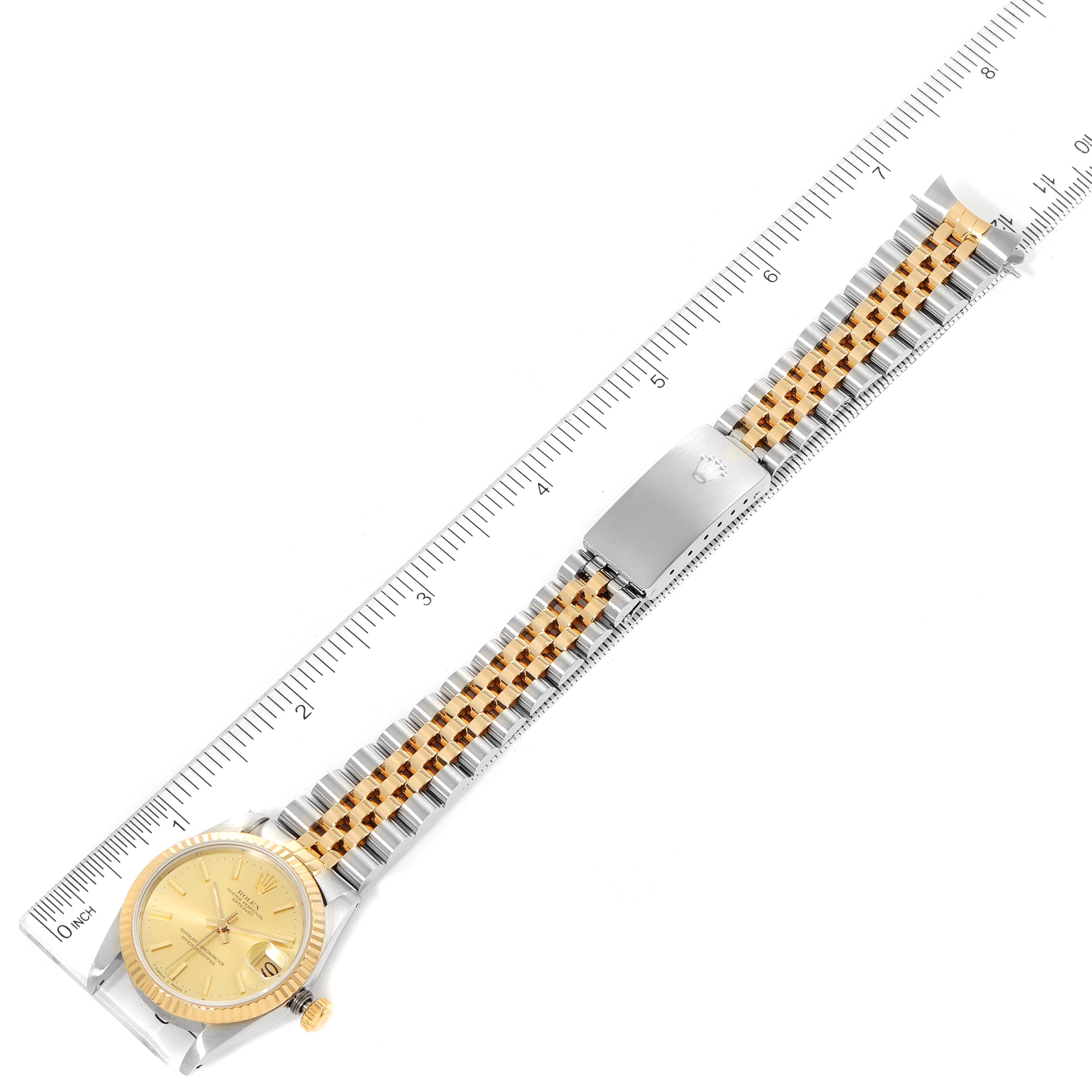 The image shows a top view of a Mid-Size Rolex watch, including the face, bezel, and bracelet with a ruler for scale.