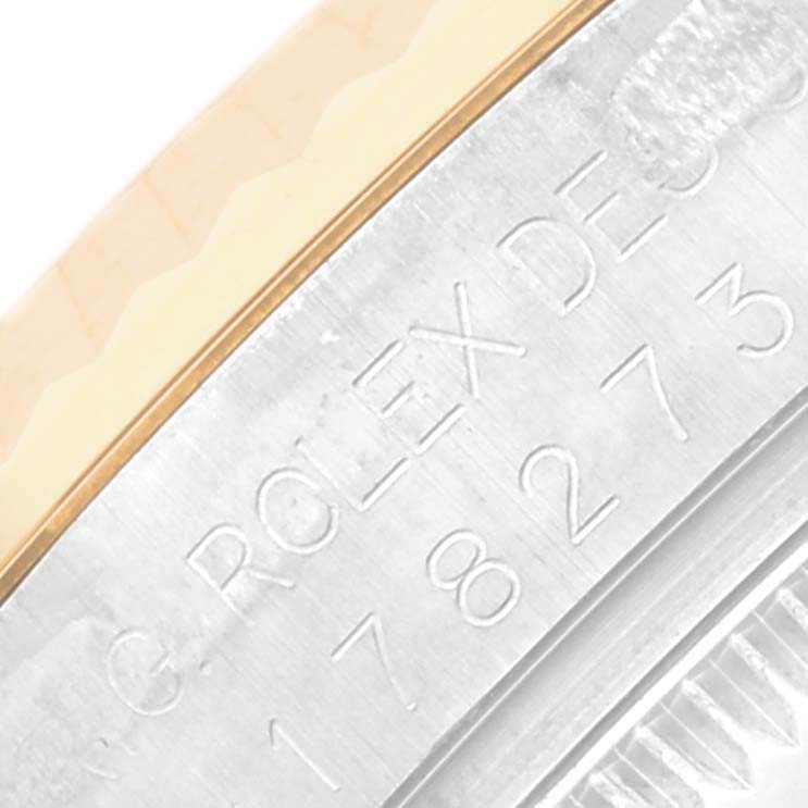 The image shows a close-up angle of the engraved side of a Rolex Mid-Size 178273 Women's Steel and Gold (two tone) Champagne Dial 178273 Women's Steel and Gold (two tone) Champagne Dial watch case.