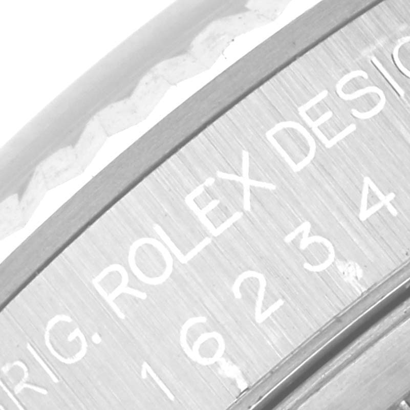 The image shows an angled close-up of the engravings on the flange of a Rolex Datejust 16234 Men
s Stainless Steel White Dial 16234 Men
s Stainless Steel White Dial watch.