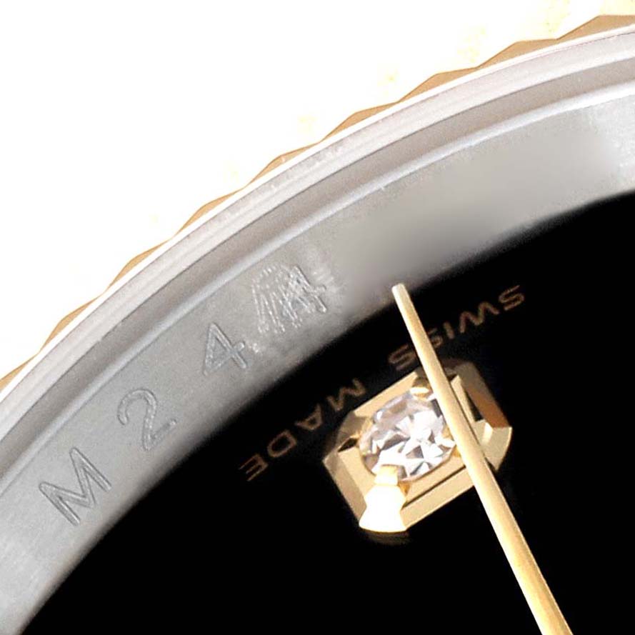 This close-up image shows the dial, part of the bezel, and markers of a Rolex Datejust 116233 Men's Steel and Gold (two tone) Black Dial 116233 Men's Steel and Gold (two tone) Black Dial watch.