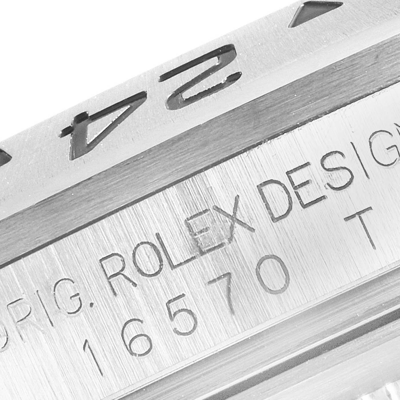 The image shows a close-up of the bezel and engraved text on a Rolex Explorer 16570 Men's Stainless Steel White Dial 16570 Men's Stainless Steel White Dial model 16570.