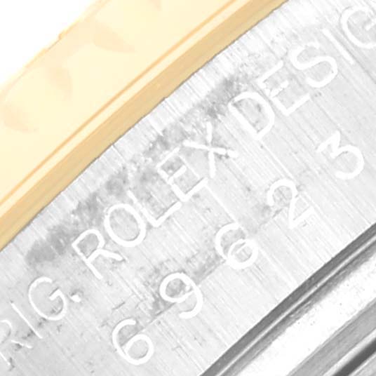 This close-up image shows an engraved part of the bezel and case of a Rolex Yacht-Master 69623 Women's Steel and Gold (two tone) White Dial 69623 Women's Steel and Gold (two tone) White Dial watch.