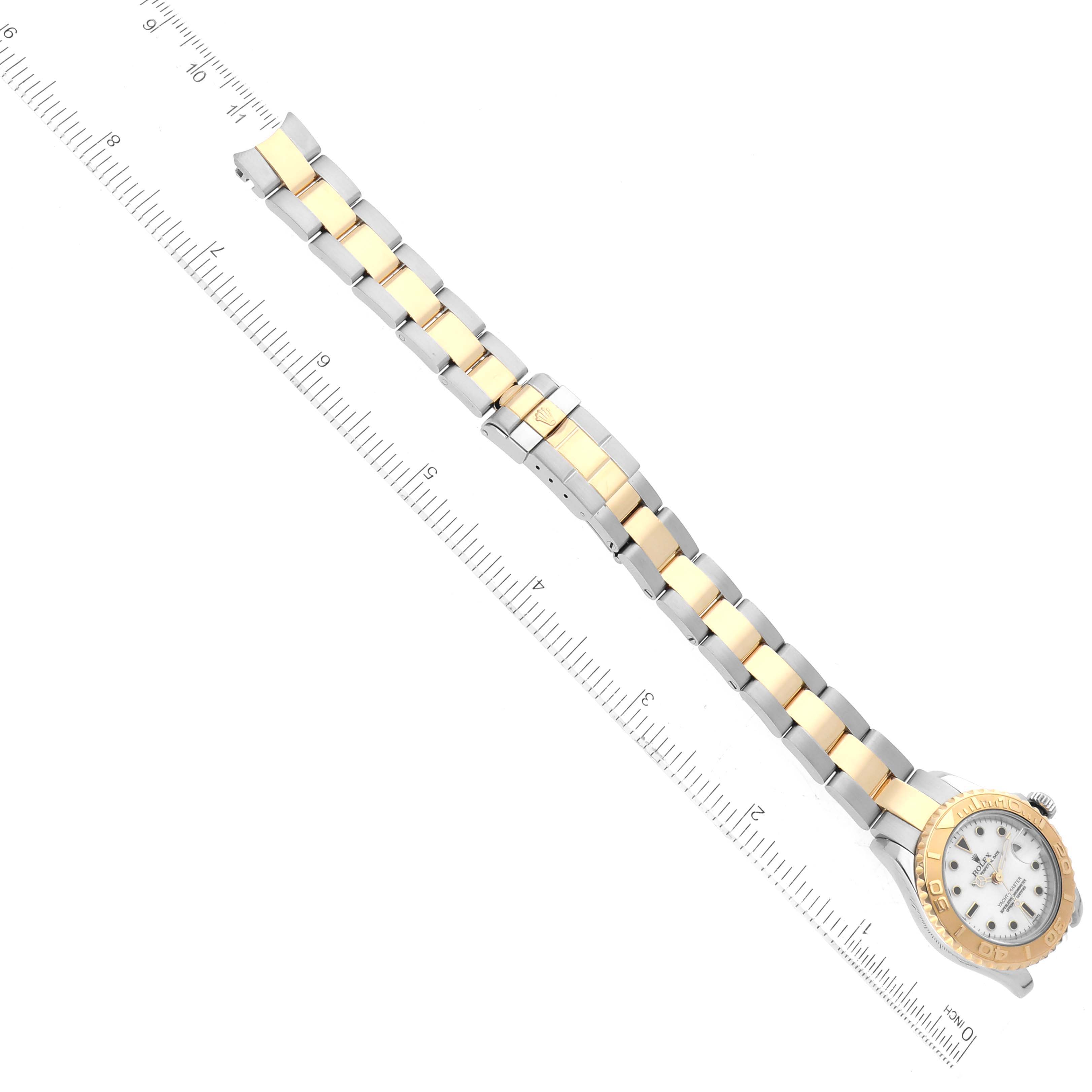 The image shows a Rolex Yacht-Master 69623 Women's Steel and Gold (two tone) White Dial 69623 Women's Steel and Gold (two tone) White Dial watch at an angle, displaying its two-tone metal bracelet and face beside a ruler for scale.