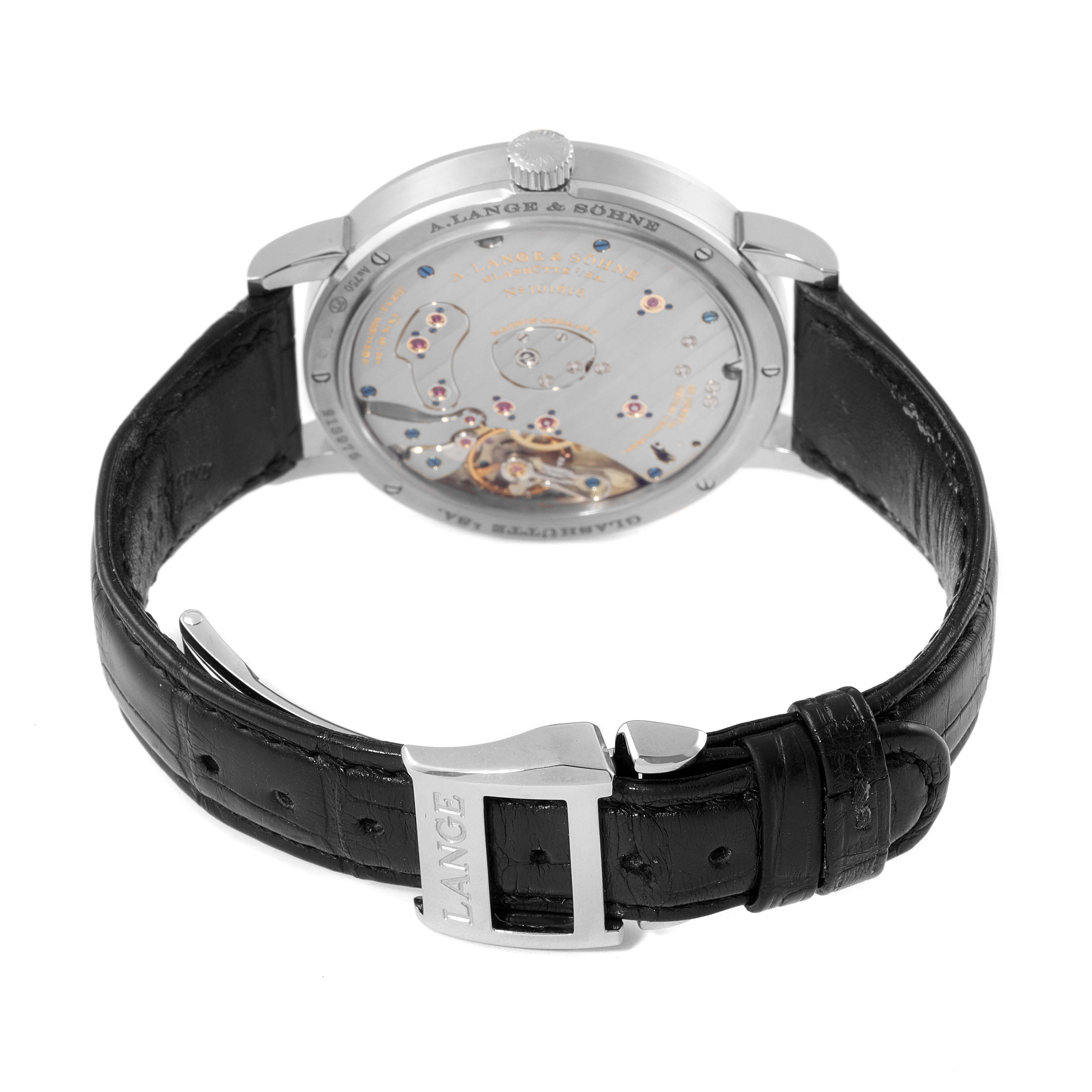 The image shows the back view of a Lange 1 model by A. Lange & Söhne, highlighting its intricate movement and leather strap.
