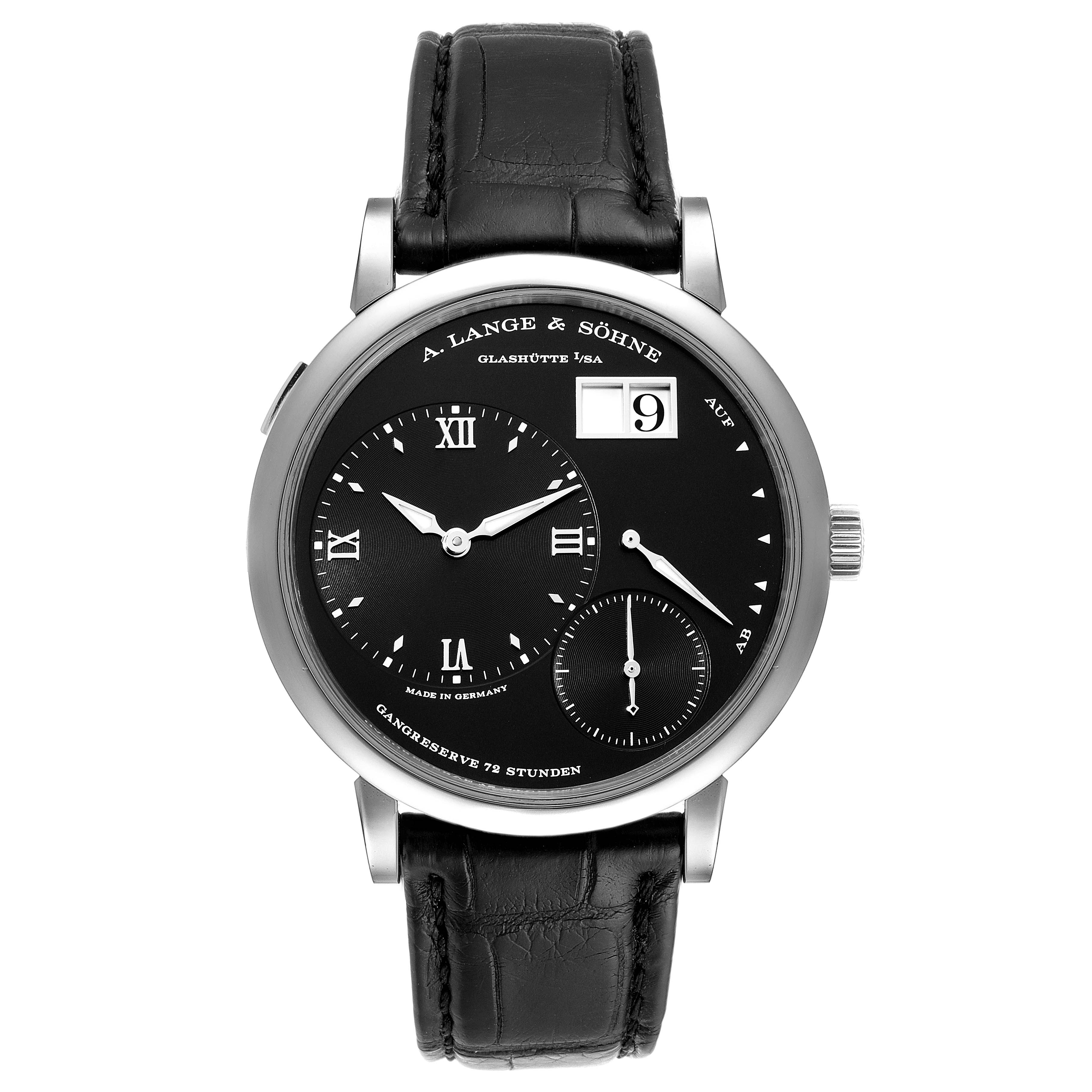 The image shows a frontal view of the A. Lange & Sohne Lange 1 117.028 Men's White Gold Black Dial watch, displaying the dial, hands, and leather strap.