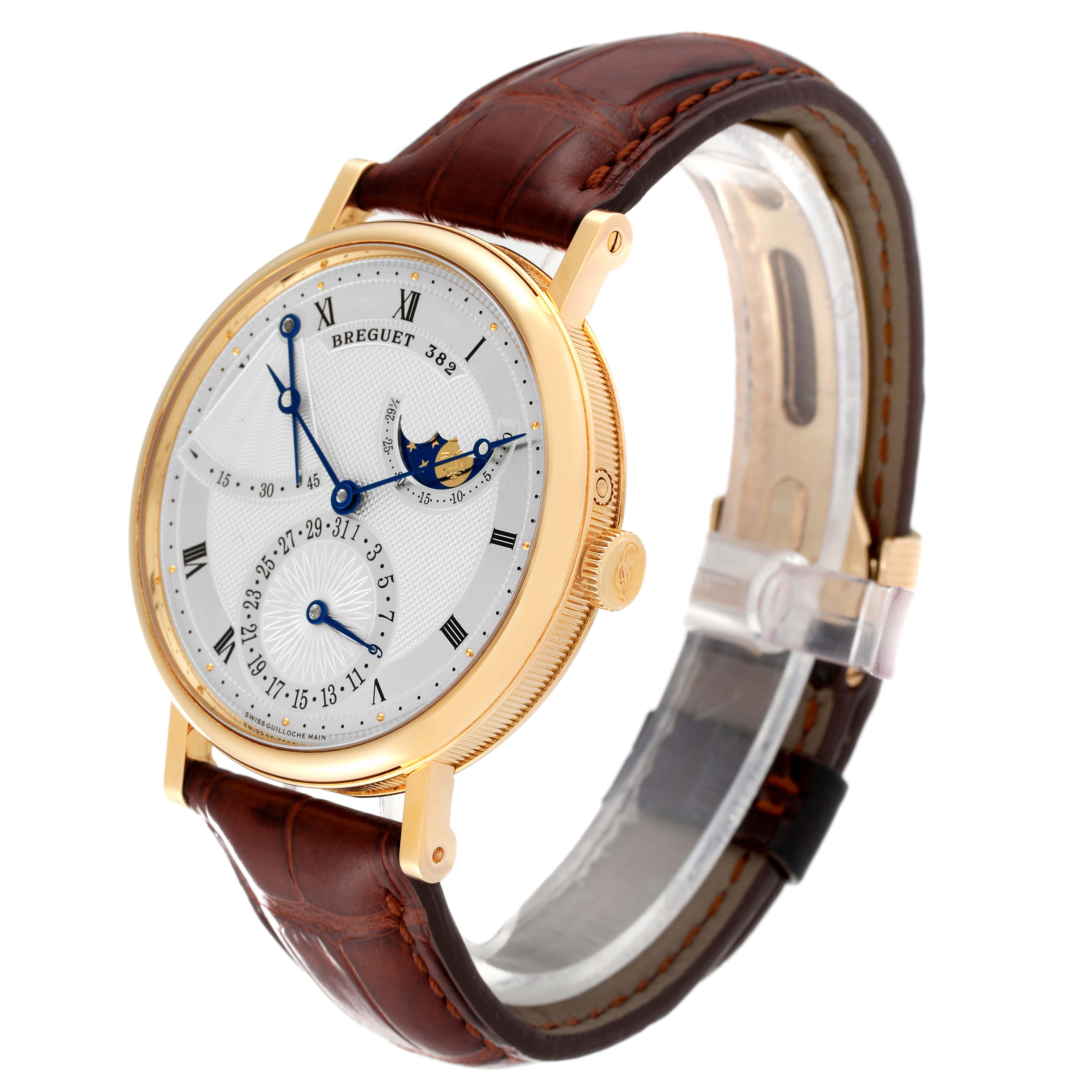 The Breguet Classique 7137BA/11/9V6 Men
s Yellow Gold Silver Dial 7137BA/11/9V6 Men
s Yellow Gold Silver Dial watch is shown at a three-quarter angle, highlighting its gold case, dial with blue accents, and brown leather strap.