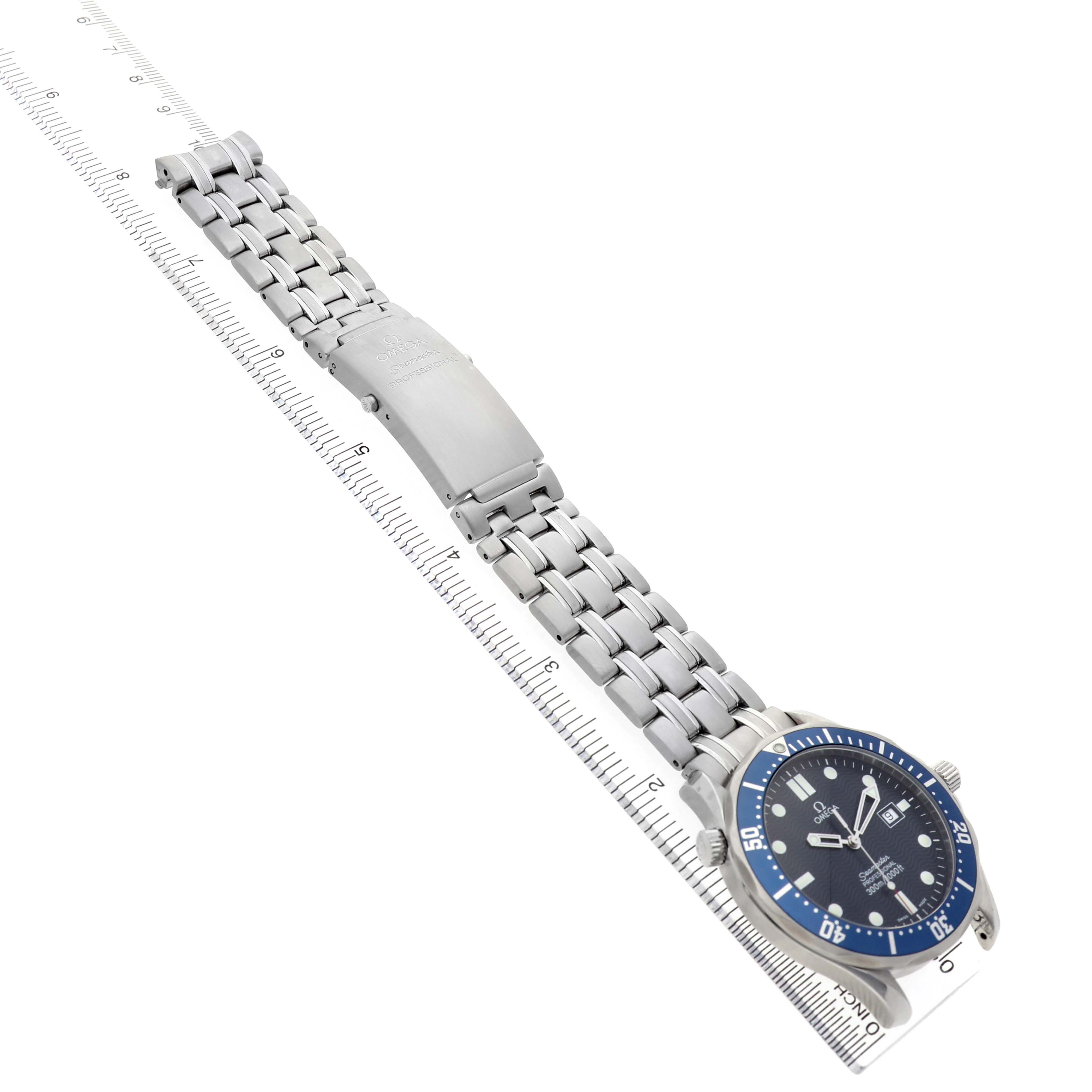 The Omega Seamaster 2541.80.00 Men's Stainless Steel Blue Dial watch is shown from an angled side view, displaying its bezel, dial, and metal bracelet atop a ruler.