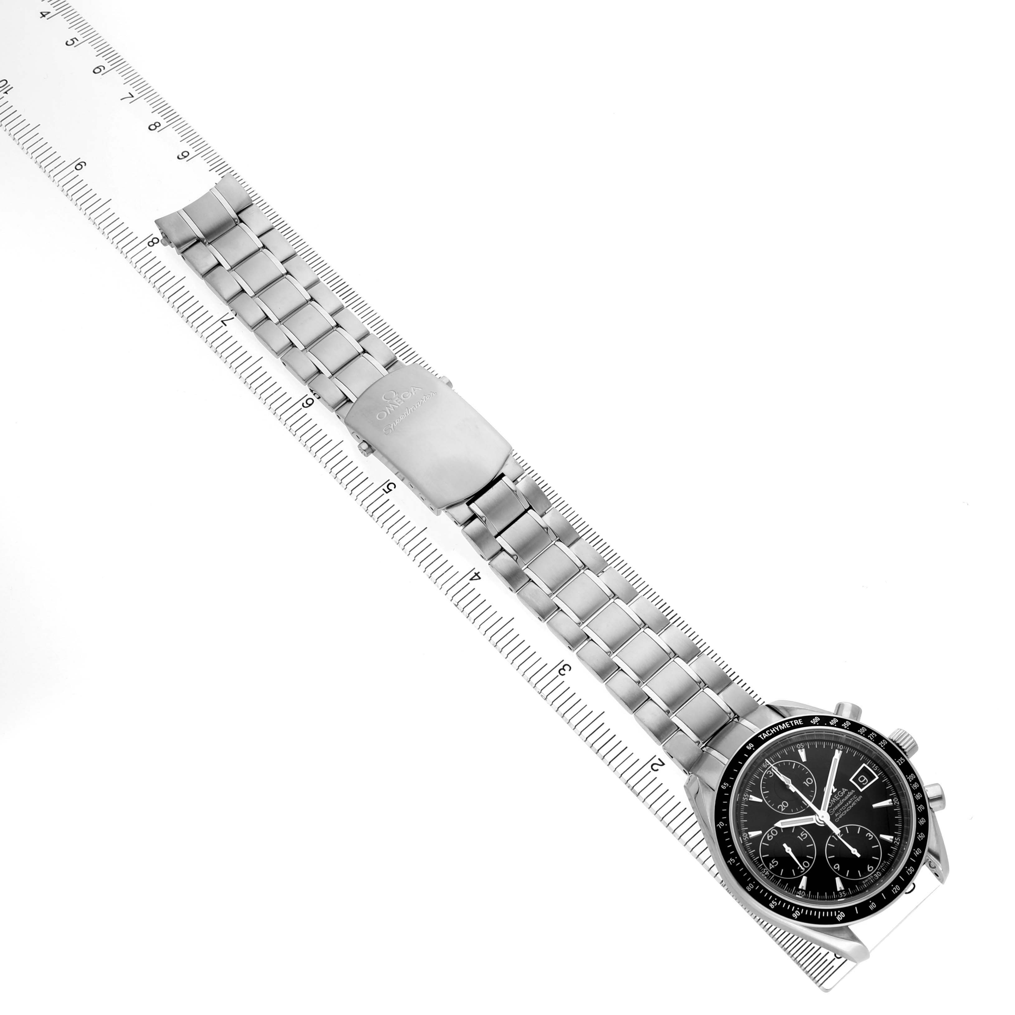 The Omega Speedmaster 3210.50.00 Men's Stainless Steel Black Dial watch is shown from an overhead angle, displaying the dial and metal bracelet alongside a ruler for scale.