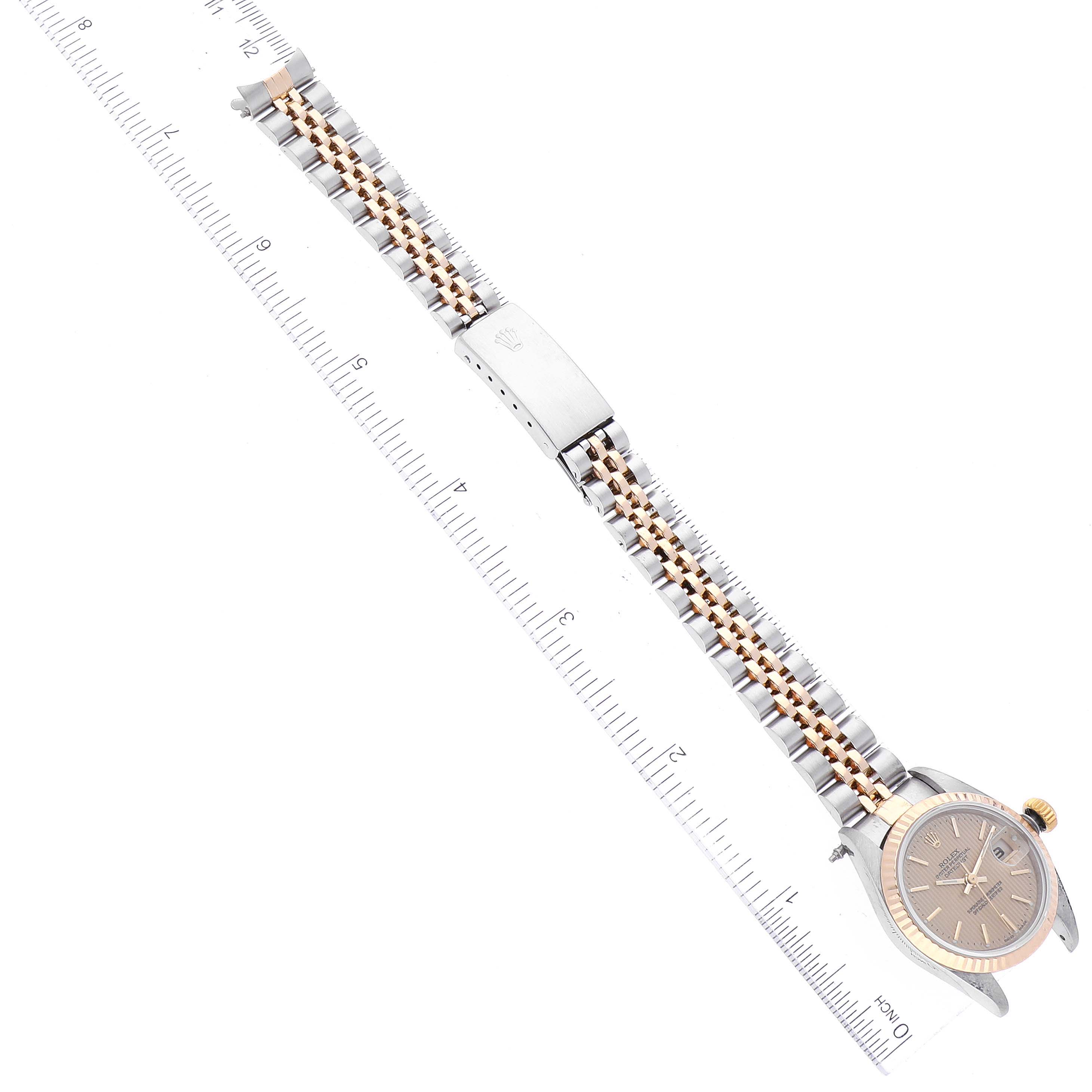The image shows a Rolex Datejust 79173 Women's Steel and Gold (two tone) Champagne Dial 79173 Women's Steel and Gold (two tone) Champagne Dial watch laid flat with a visible face, two-tone bracelet, and a ruler measuring its length.