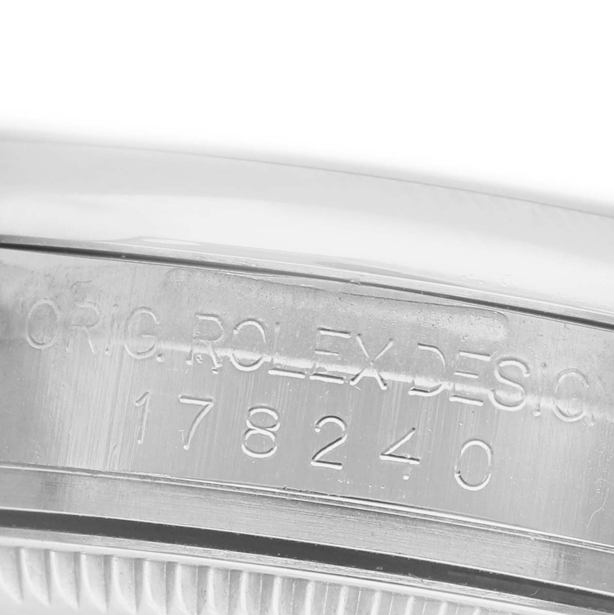 The image shows a close-up of the side of a Rolex Datejust 178240 Women's Stainless Steel Pink Dial watch, focusing on the engraved serial number and design text.