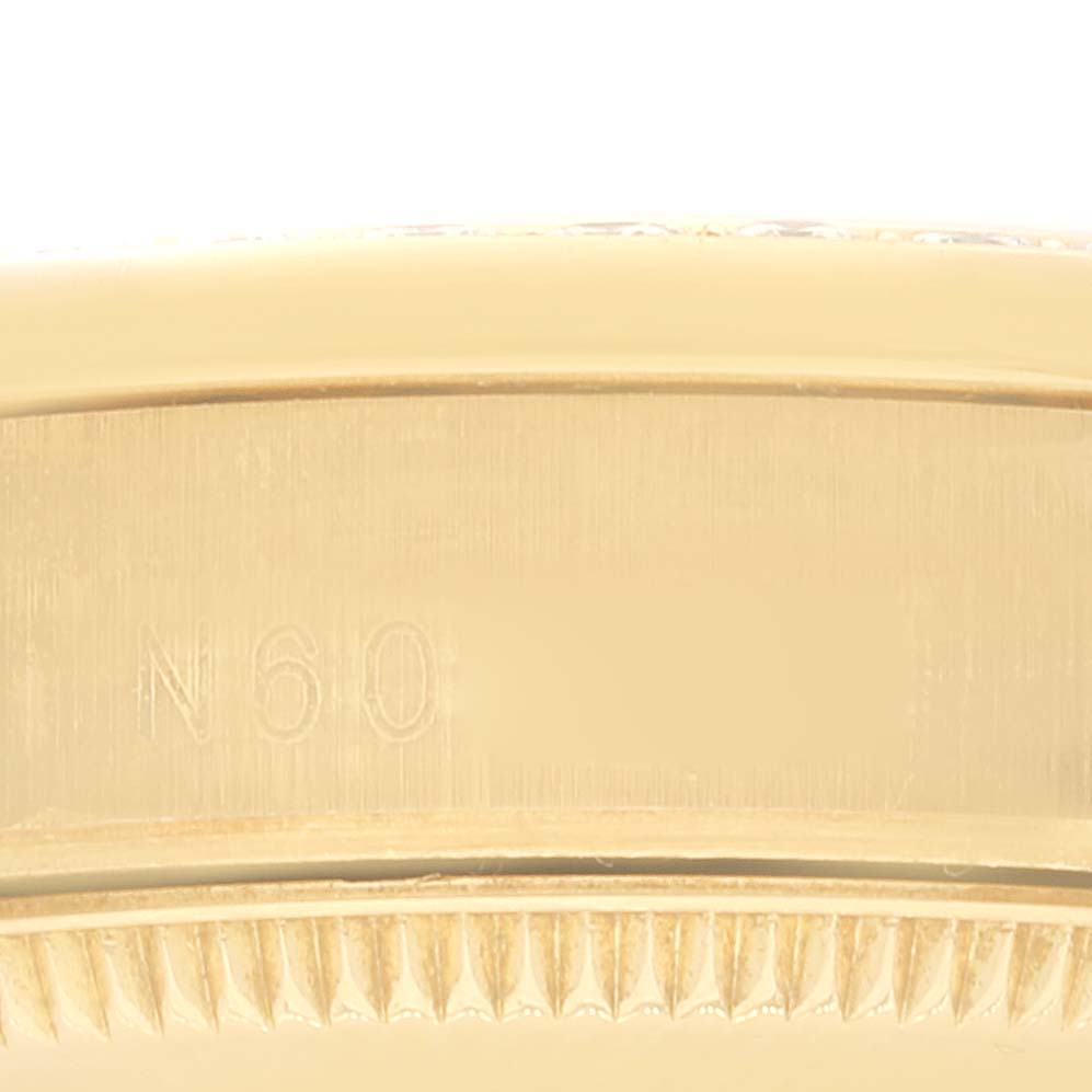 The image shows a close-up of the side of a Rolex President 68158 Women
s Yellow Gold Champagne Dial 68158 Women
s Yellow Gold Champagne Dial model watch, featuring a serial number and the edge of the bezel.