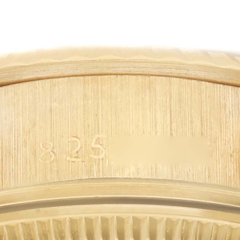 This close-up image shows the edge of a Rolex President 69178 Women's Yellow Gold Mother of Pearl Dial 69178 Women's Yellow Gold Mother of Pearl Dial model watch, highlighting part of its bezel and serial number.