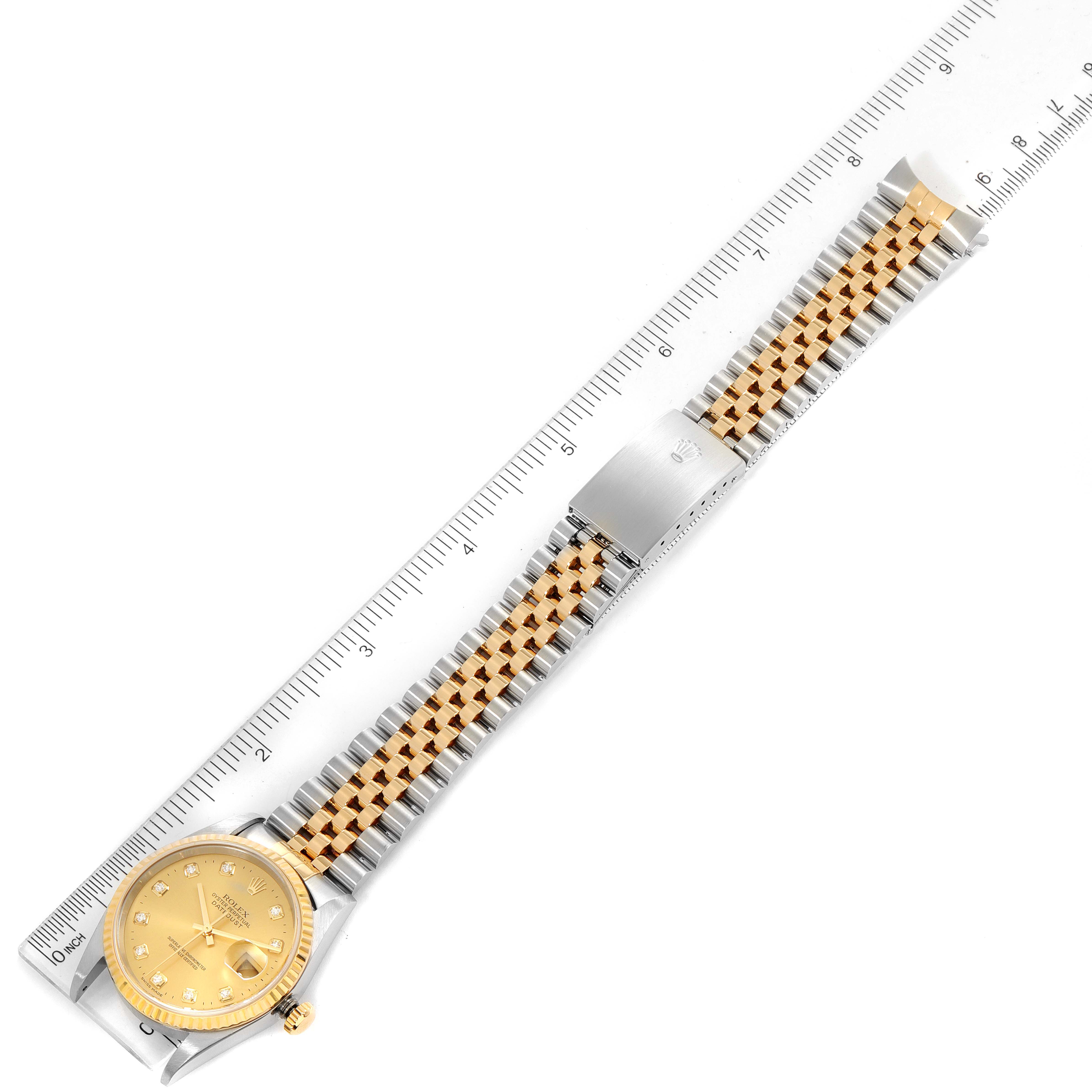 This image shows a top view of a Rolex Datejust 16233 Men's Steel and Gold (two tone) Champagne Dial 16233 Men's Steel and Gold (two tone) Champagne Dial watch, displaying its face, bracelet, and clasp next to a ruler.