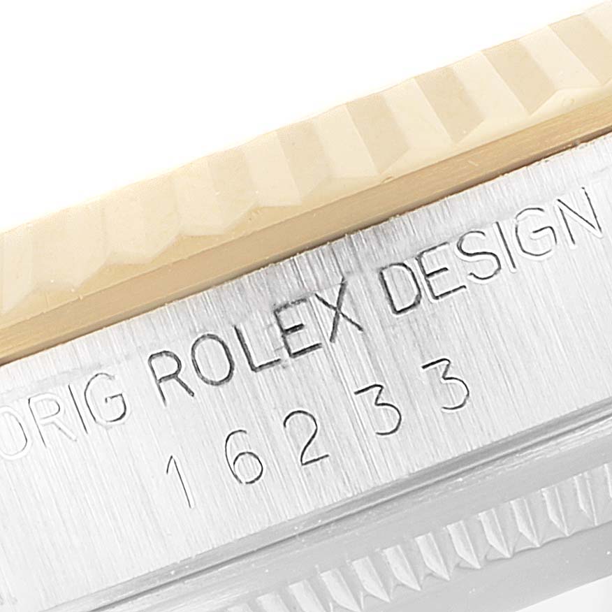 This image shows a close-up view of the engraved case side and fluted bezel of a Rolex Datejust 16233 Men's Steel and Gold (two tone) Champagne Dial 16233 Men's Steel and Gold (two tone) Champagne Dial model.