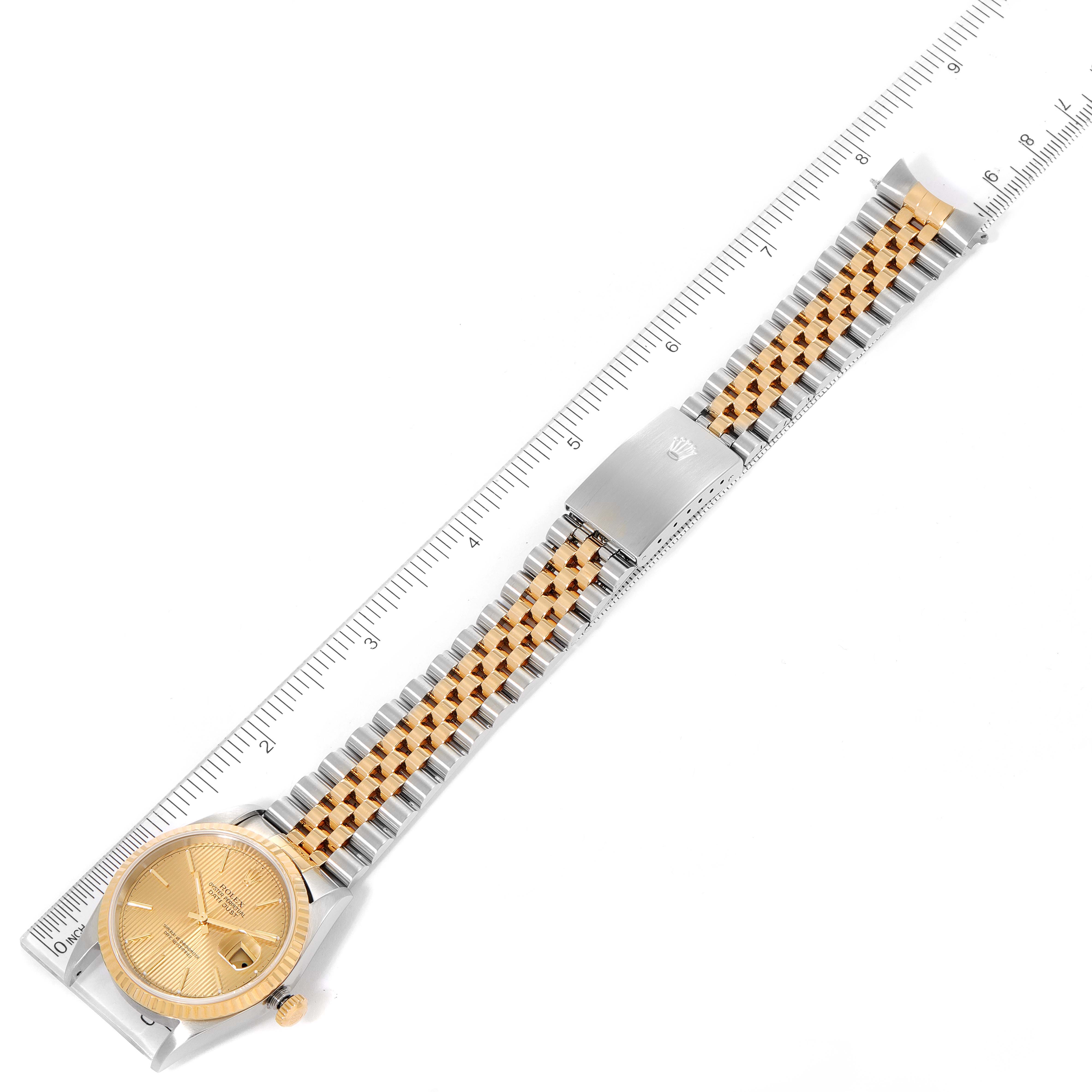 This image shows a Rolex Datejust 16233 Men's Steel and Gold (two tone) Champagne Dial 16233 Men's Steel and Gold (two tone) Champagne Dial watch laid flat with a ruler for scale, highlighting the dial, crown, and bracelet.