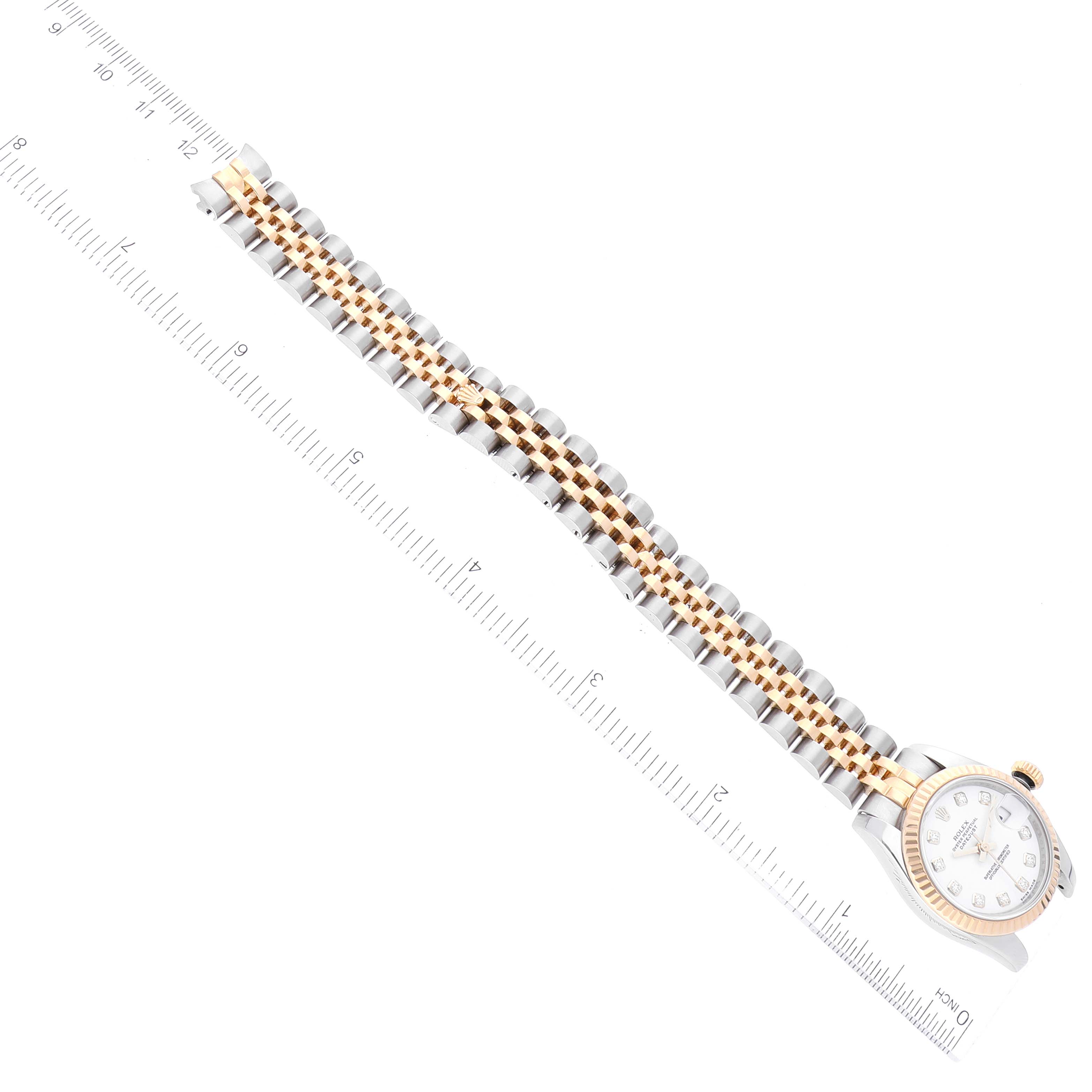 The image shows a Rolex Datejust 179173 Women's Steel and Gold (two tone) White Dial 179173 Women's Steel and Gold (two tone) White Dial watch laid flat alongside a ruler, displaying its dial, bezel, and two-tone bracelet.