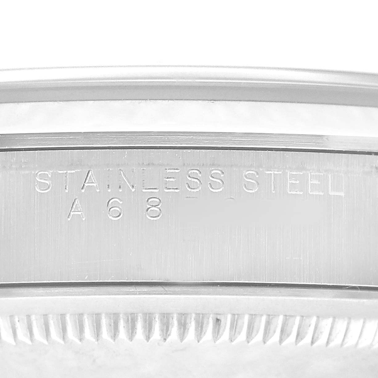 The image shows the engraved side of a Rolex Explorer 14270 Men's Stainless Steel Black Dial watch case, focusing on the "STAINLESS STEEL" marking.