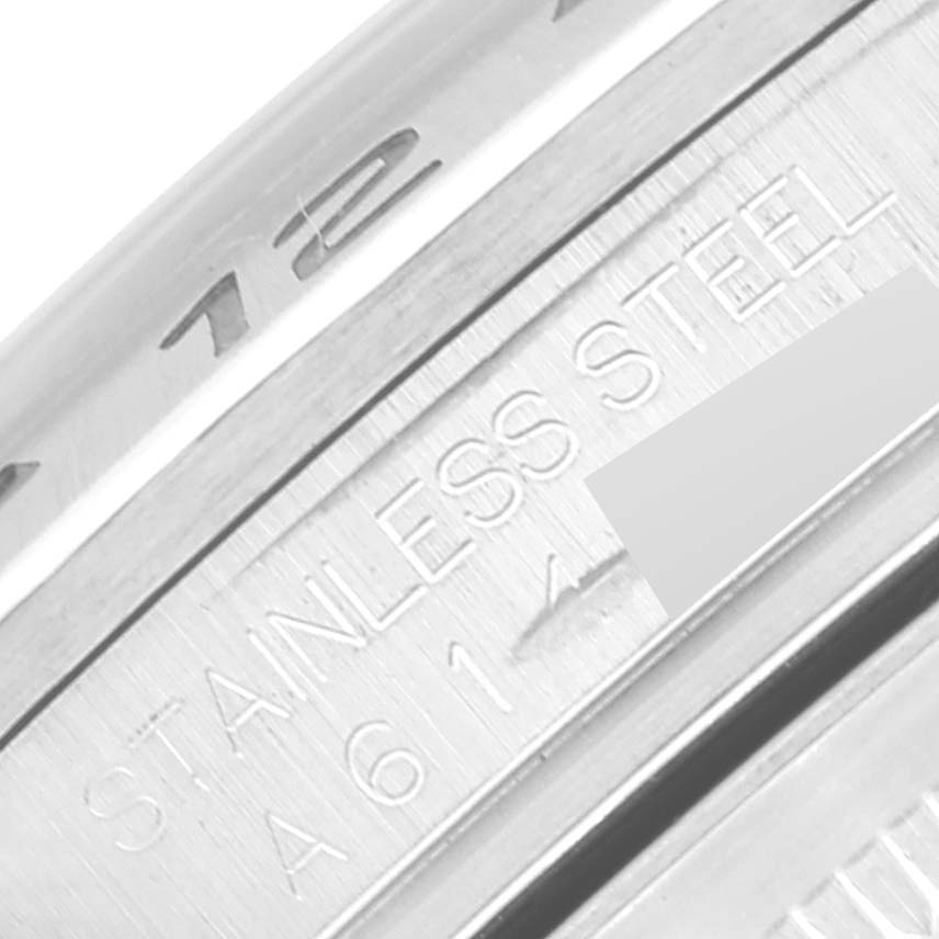 This image shows a close-up of the Rolex Explorer 16570T Men
s Stainless Steel Black Dial 16570T Men
s Stainless Steel Black Dial model
s case with "Stainless Steel" and partially visible serial number engraving.