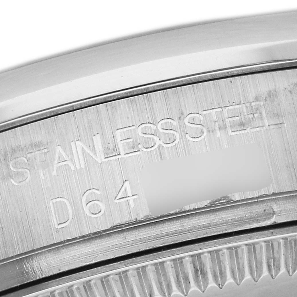 This image shows a close-up of the case back engraving on a mid-size Rolex watch, highlighting "STAINLESS STEEL" and a serial number.