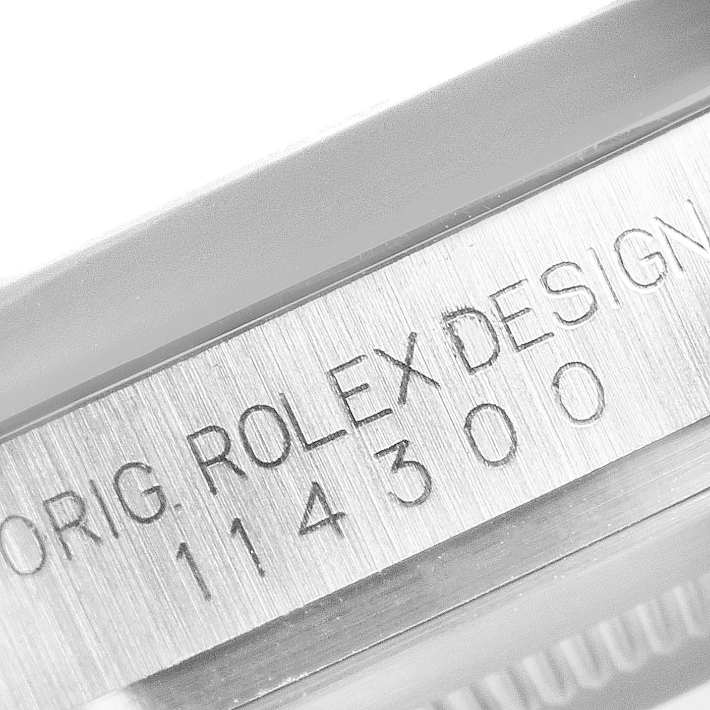 This close-up image shows the serial number engraving on the side of the casing of a Rolex Oyster Perpetual 114300 Men's Stainless Steel Silver Dial 114300 Men's Stainless Steel Silver Dial watch.