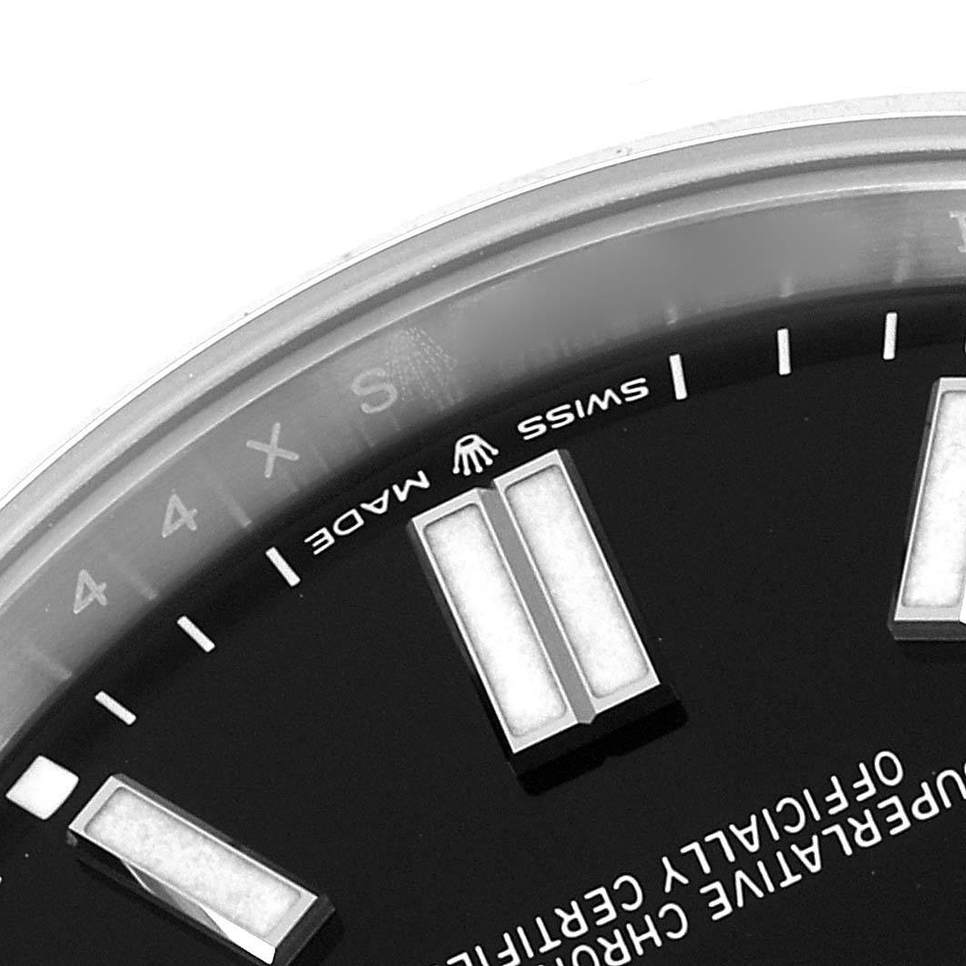 The image shows a close-up of the dial of a Rolex Oyster Perpetual 124300 Men's Stainless Steel Black Dial 124300 Men's Stainless Steel Black Dial watch with visible markers and text.
