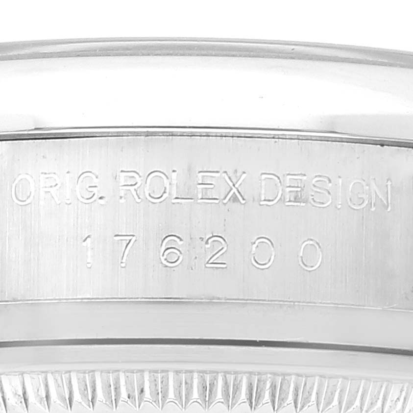 This image shows a close-up of the Rolex Oyster Perpetual 176200 Women's Stainless Steel Silver Dial 176200 Women's Stainless Steel Silver Dial watch's side engraving and a portion of its bezel.