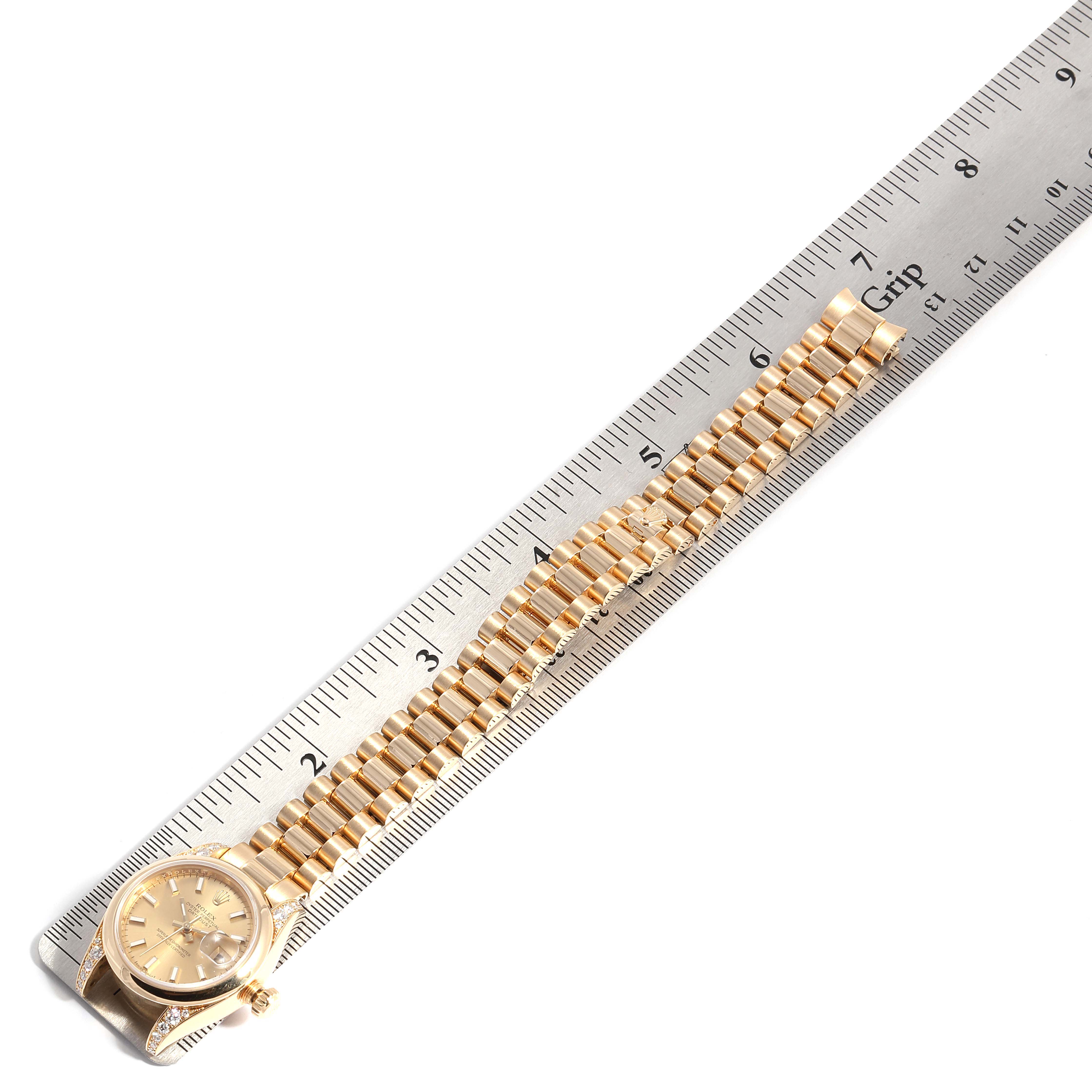 The Rolex President 179298 Women
s Yellow Gold Champagne Dial 179298 Women
s Yellow Gold Champagne Dial watch is shown laid flat with its band parallel to a ruler displaying its length.