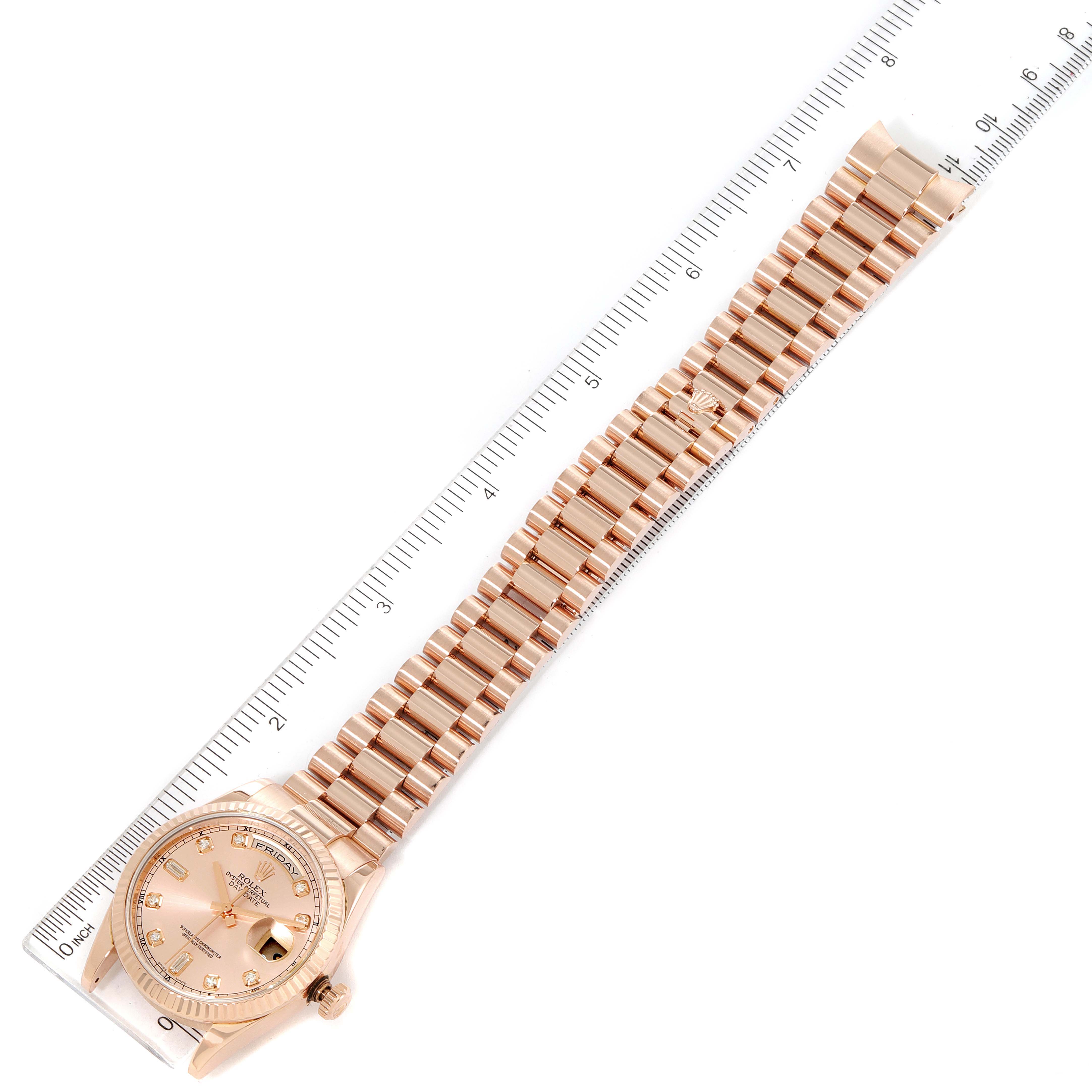 The photo shows a Rolex President 118235 Men's Rose Gold Pink Dial 118235 Men's Rose Gold Pink Dial watch laid flat with the entire bracelet and face visible, aligned next to a ruler.