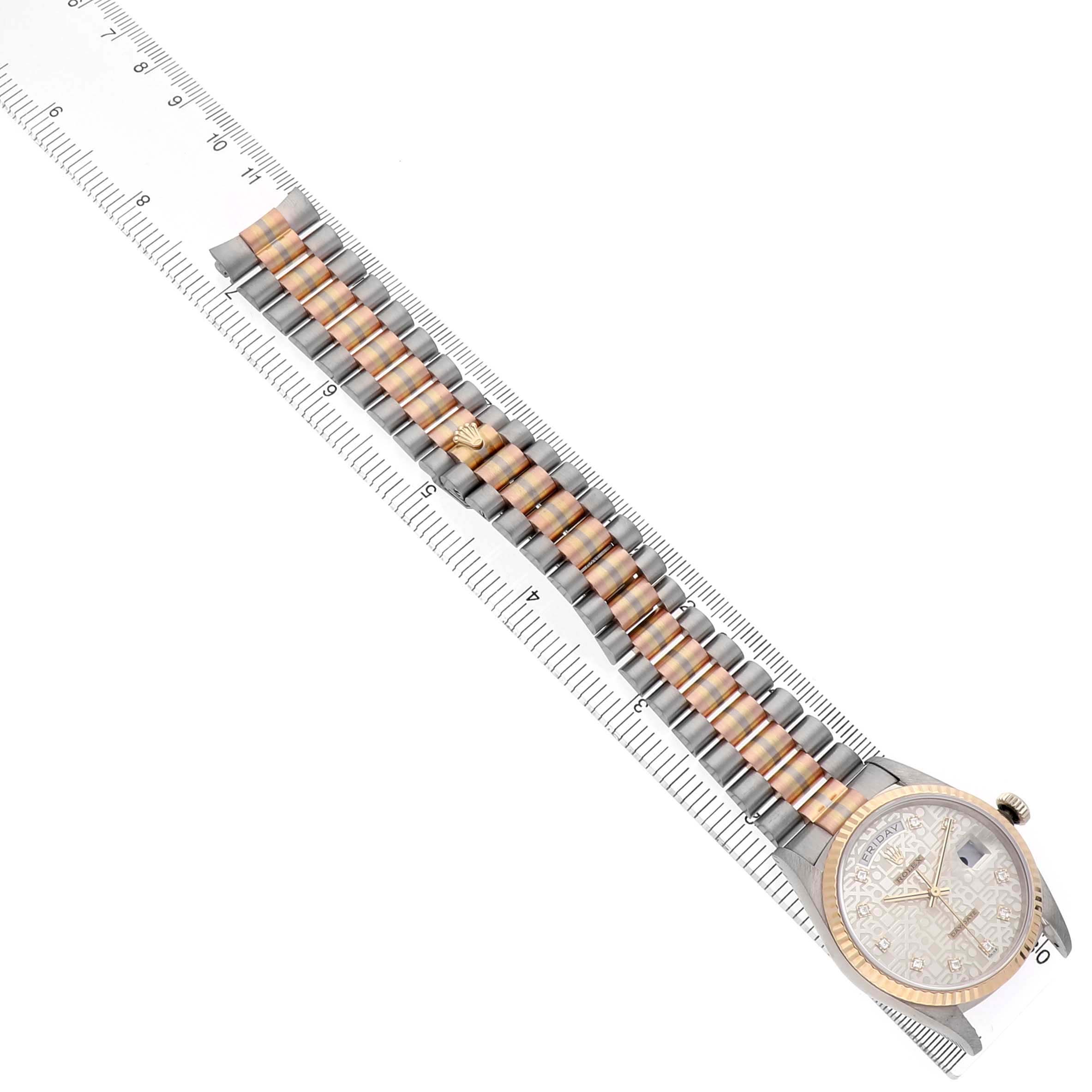 The image shows the Rolex President 18239 Men's White Gold Silver Dial watch laid flat on a ruler, highlighting the band and face.