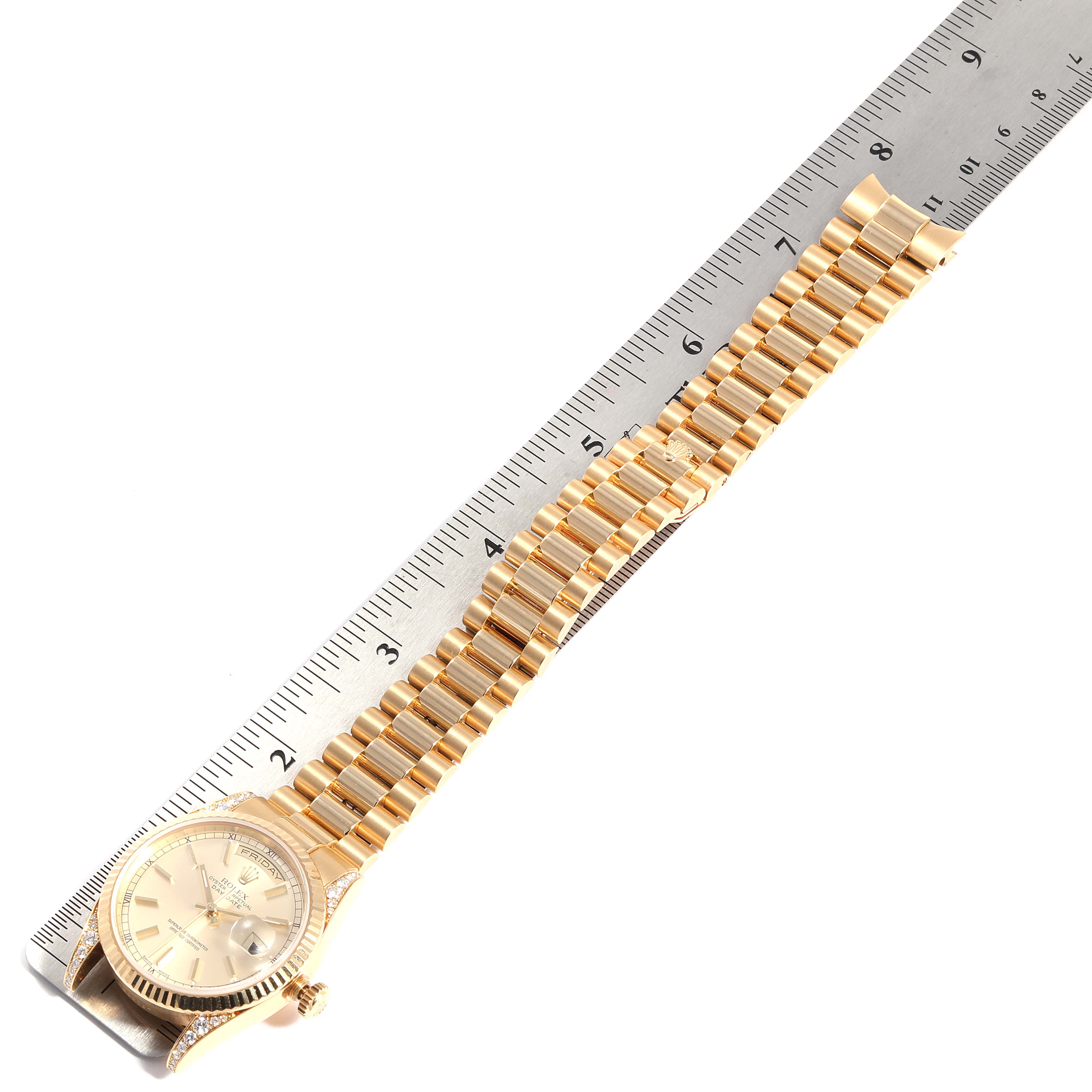 This image shows a Rolex President 118338 Men
s Yellow Gold Champagne Dial 118338 Men
s Yellow Gold Champagne Dial model watch laid flat with the face and bracelet aligned next to a ruler.