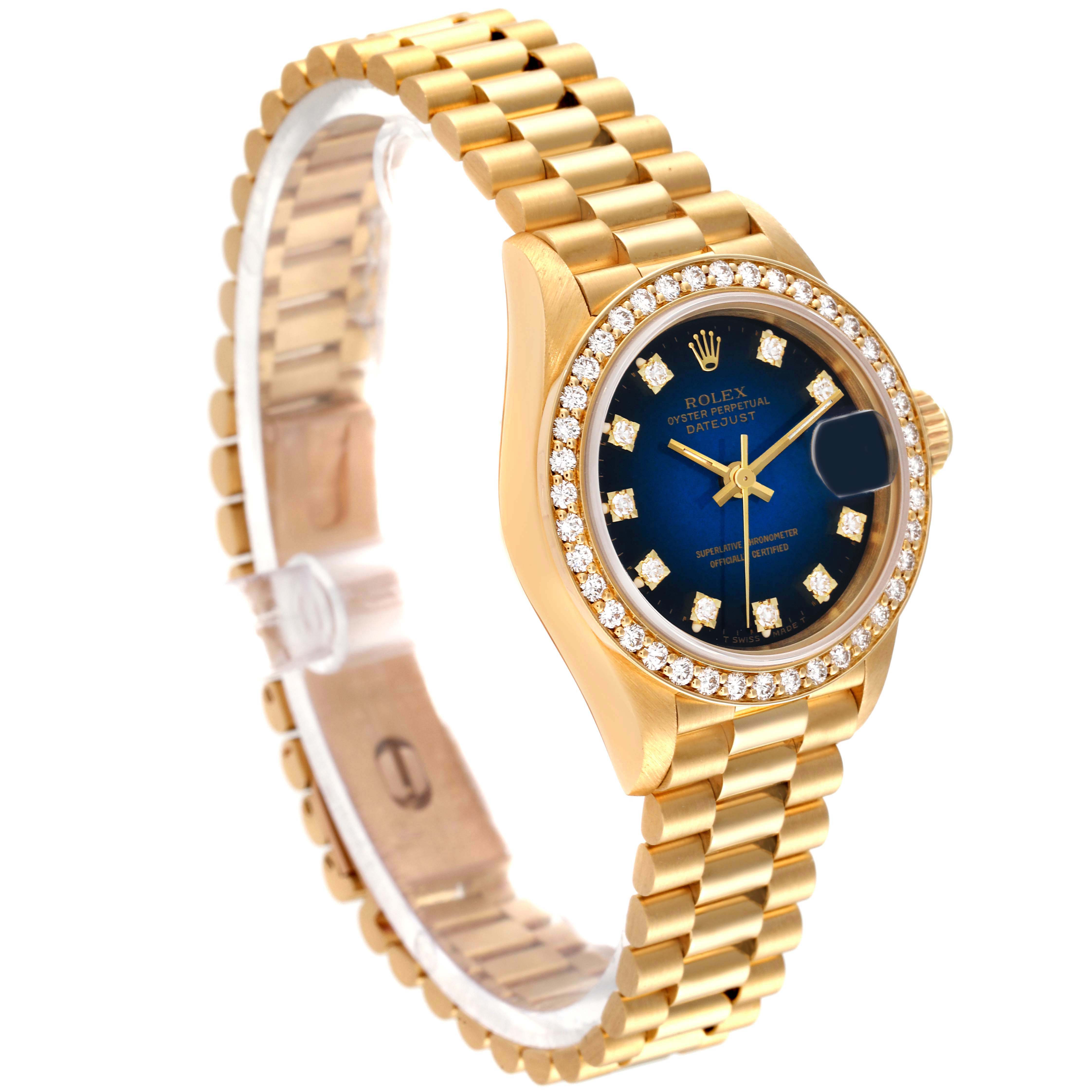 The photo shows a Rolex President 69138 Women's Yellow Gold Blue Dial 69138 Women's Yellow Gold Blue Dial model watch at an angled view, highlighting the gold band, blue dial, and diamond bezel.