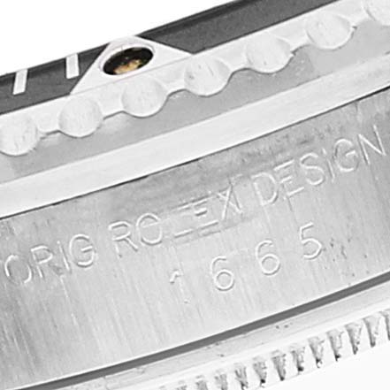 The image shows a close-up of the bezel and engraved side of a Rolex Vintage Collection 1665 Men's Stainless Steel Black Dial 1665 Men's Stainless Steel Black Dial model watch.