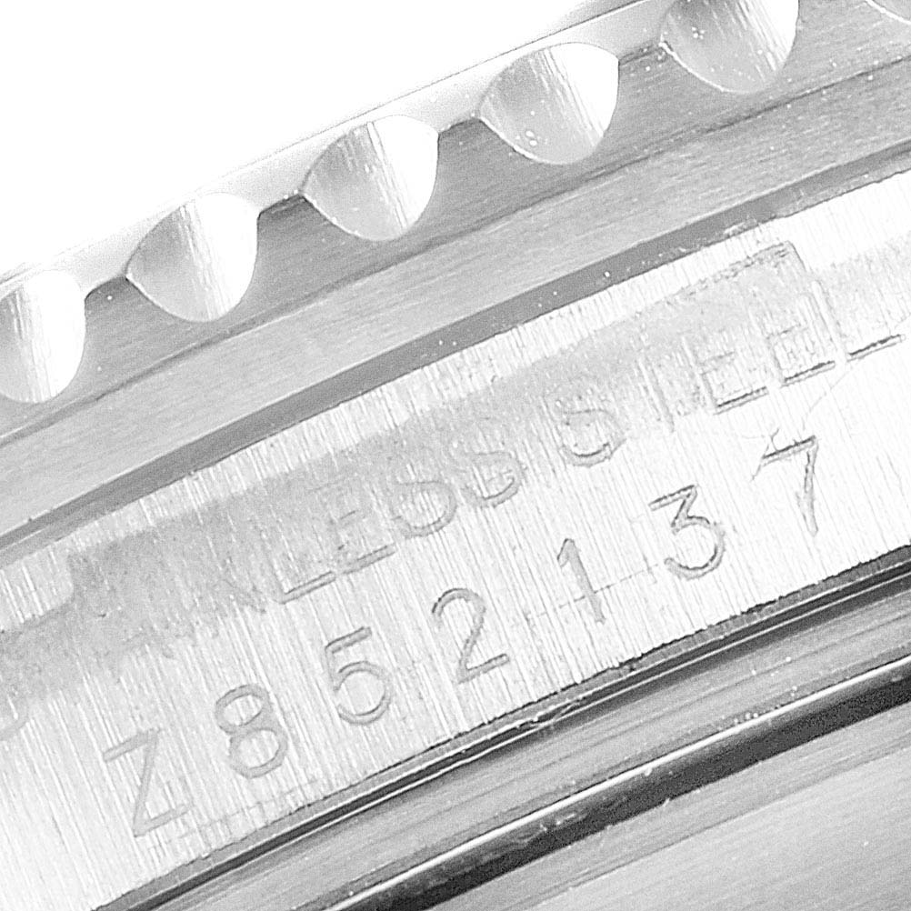 The image shows a close-up of the Rolex Submariner 16610LV Men's Stainless Steel Black Dial 16610LV Men's Stainless Steel Black Dial's case edge, featuring the model's serial number engraved on stainless steel.